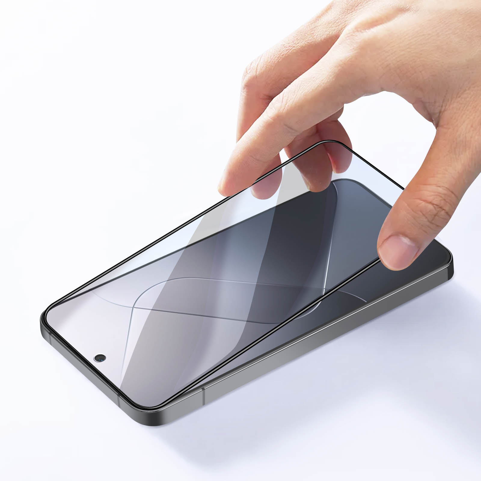 Una mano posiziona una protezione per lo schermo su uno smartphone grigio.
