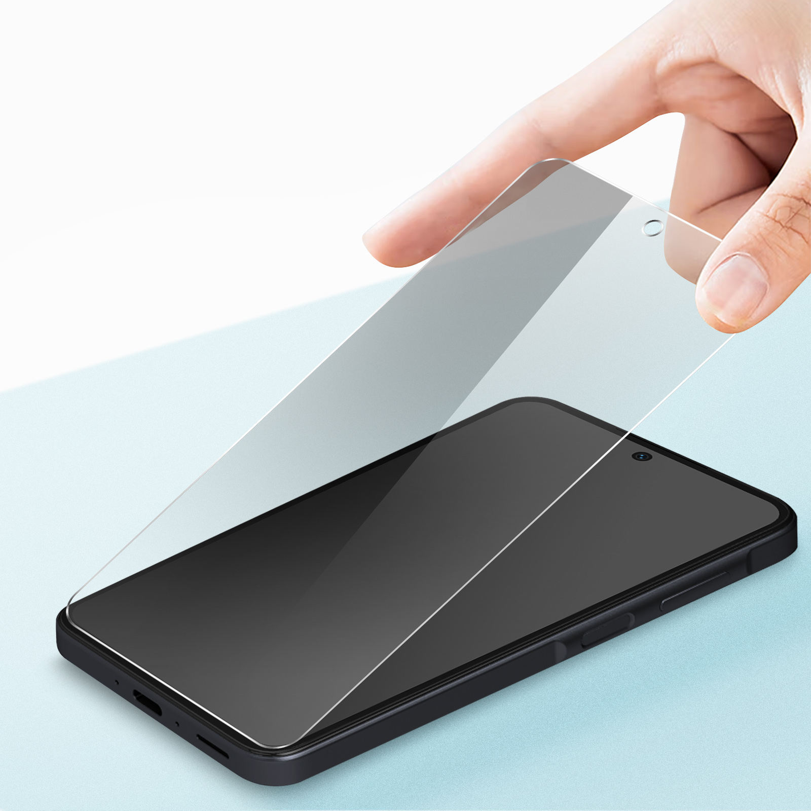 Una mano tiene una protezione per lo schermo sopra uno smartphone nero.