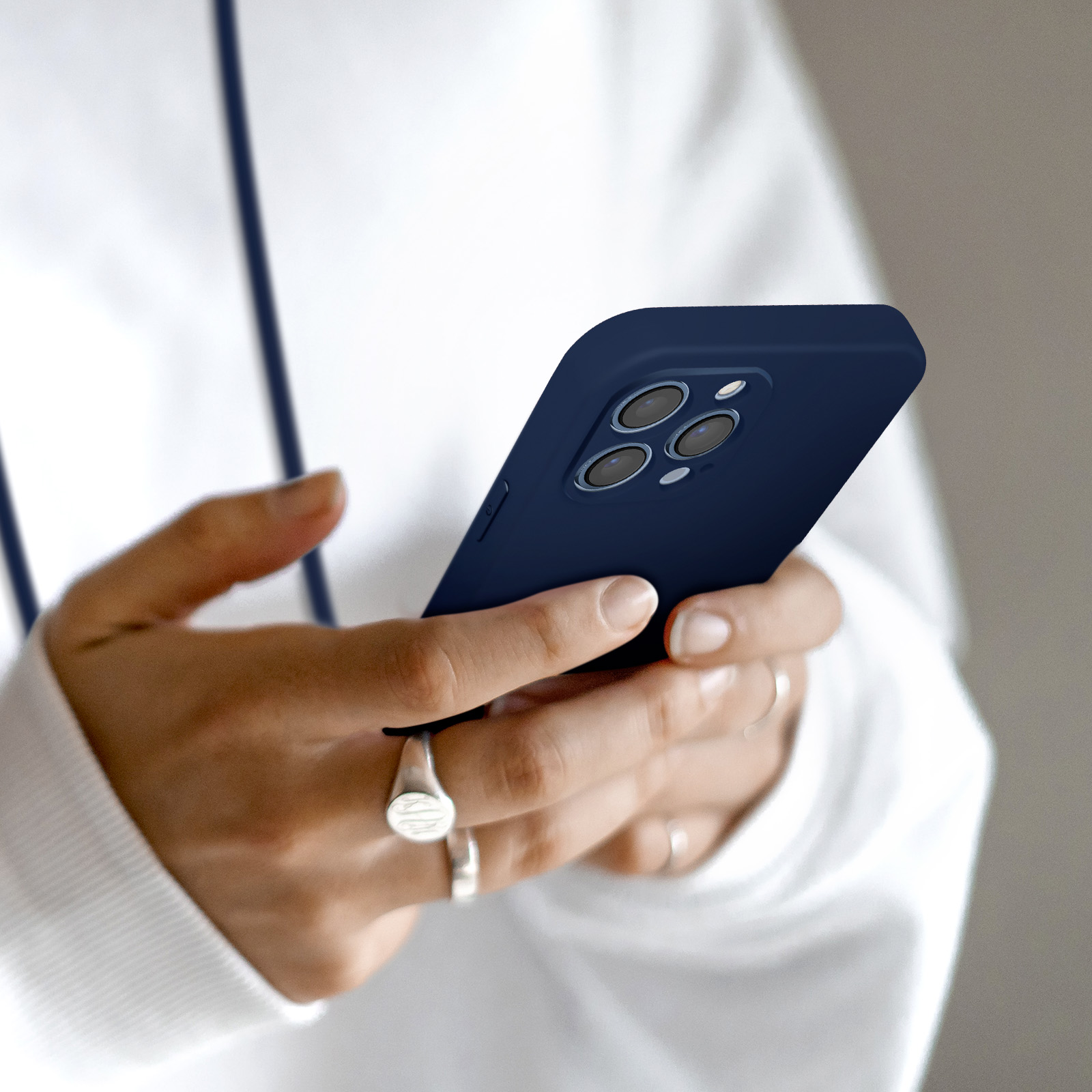 Una persona tiene un telefono blu scuro con tre obiettivi.