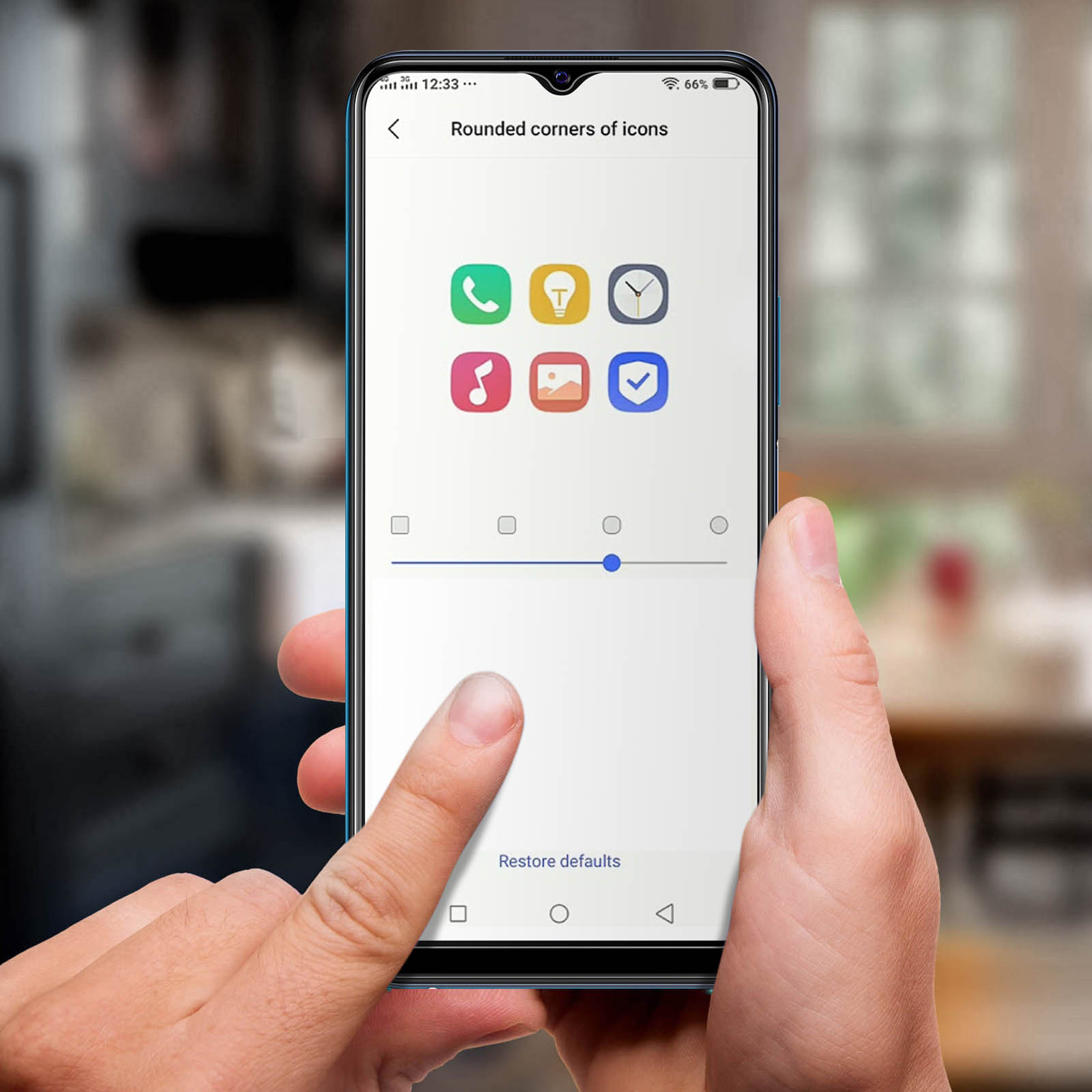 Un dito regola gli angoli arrotondati delle icone su uno schermo smartphone.