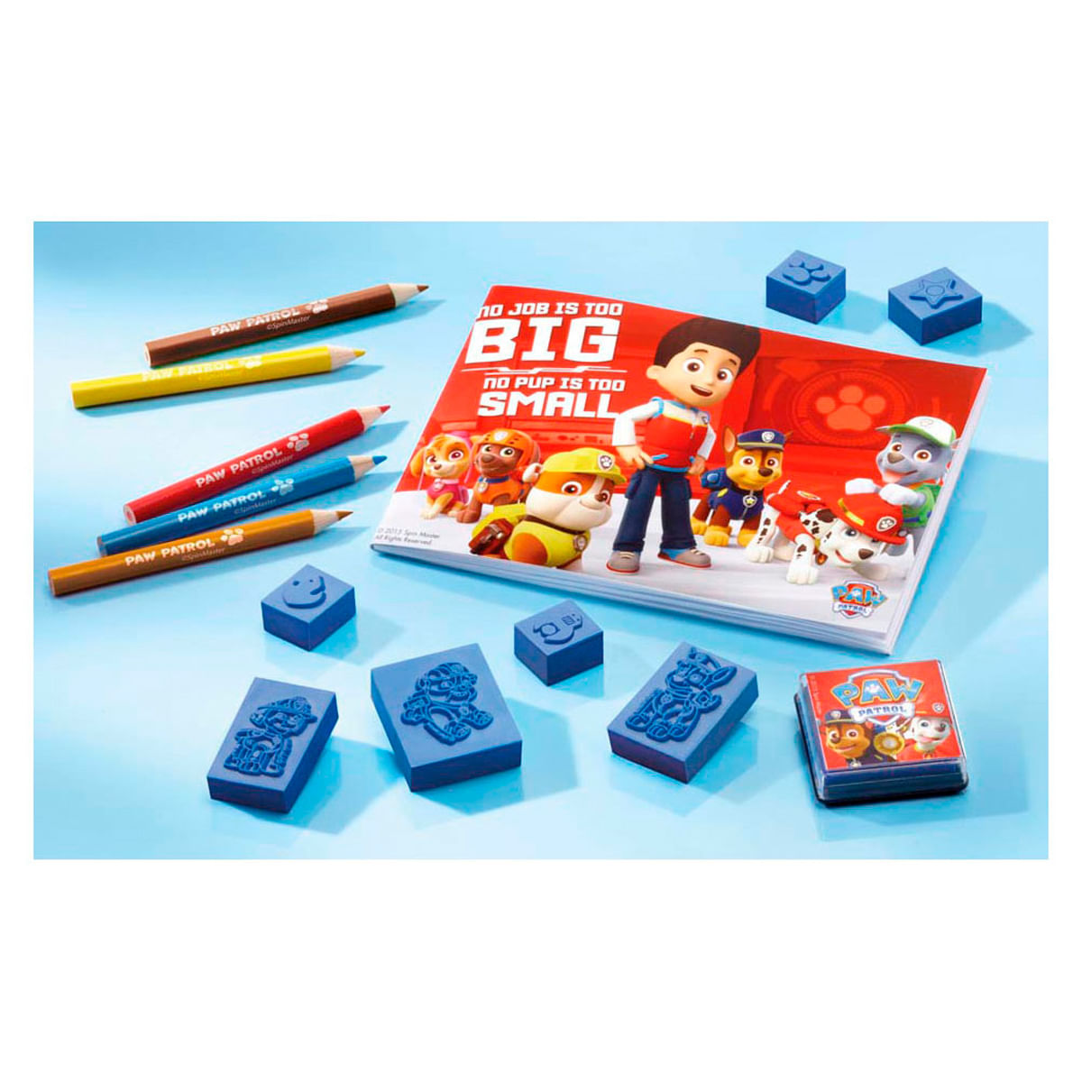 Crayones, sellos y libro de Paw Patrol con personajes sobre fondo azul.