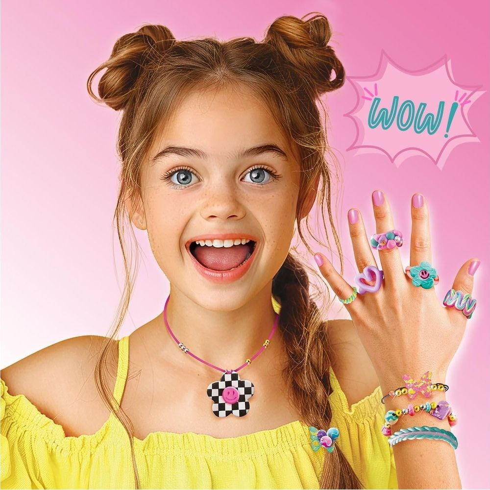 Una niña con dos moños lleva anillos, pulseras y un collar coloridos.