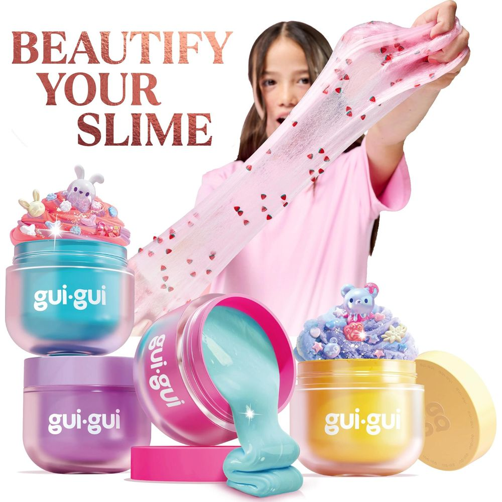 Niña juega con slime rosa con corazones. Varios recipientes de slime coloridos.