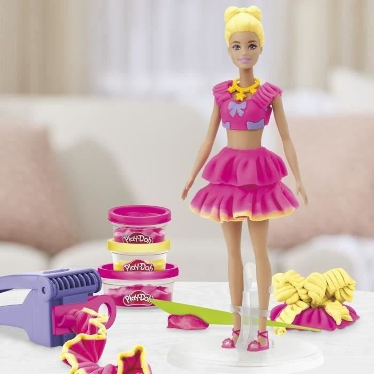 Muñeca Barbie con atuendo rosa, recipientes Play-Doh y extrusora morada.