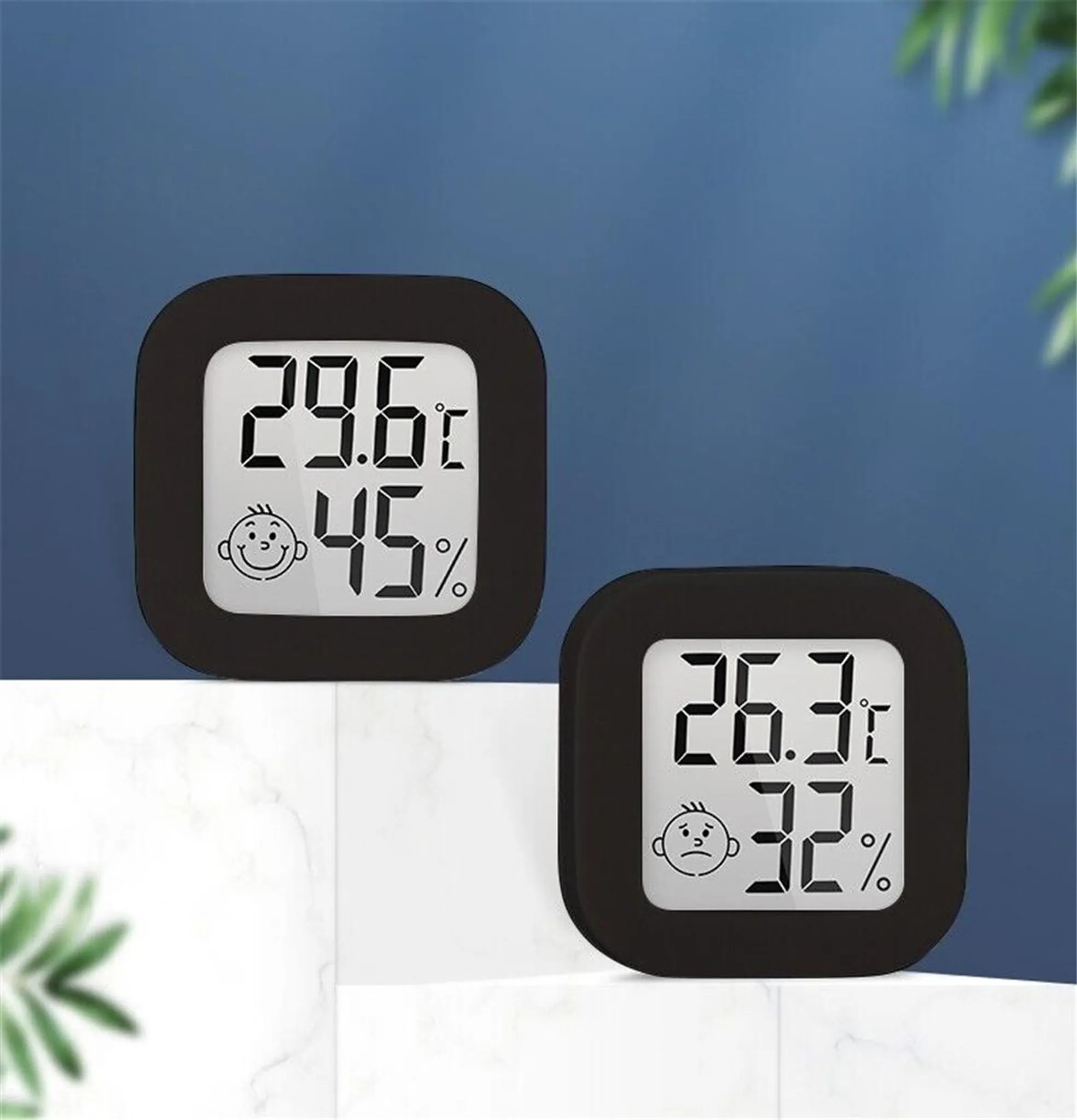 Zwei schwarze Digitalthermometer zeigen Temperatur und Luftfeuchtigkeit. Eines zeigt 29,6C, 45%. Das andere zeigt 26,3C, 32%.