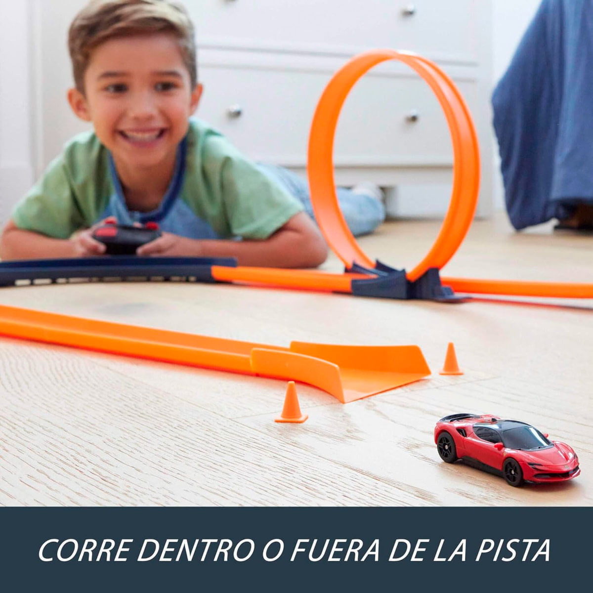 Un niño juega con una pista de coches de juguete roja con bucles.