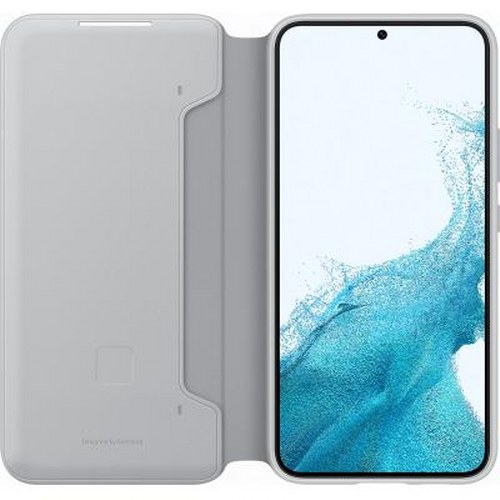 Una funda gris claro para smartphone está abierta junto a un smartphone con fondo de pantalla azul.