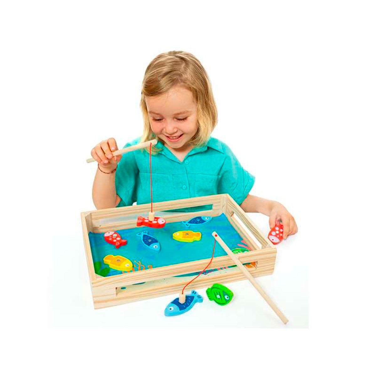 Una niña juega con un juguete de pesca de madera con peces de colores.