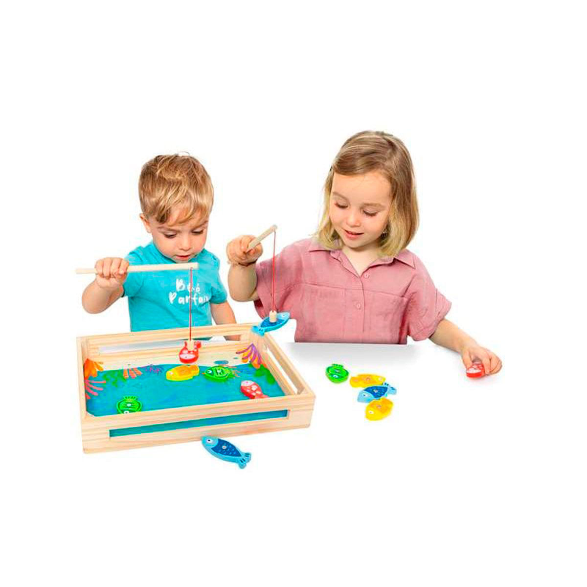 Dos niños juegan a pescar con peces de juguete en una caja de madera.
