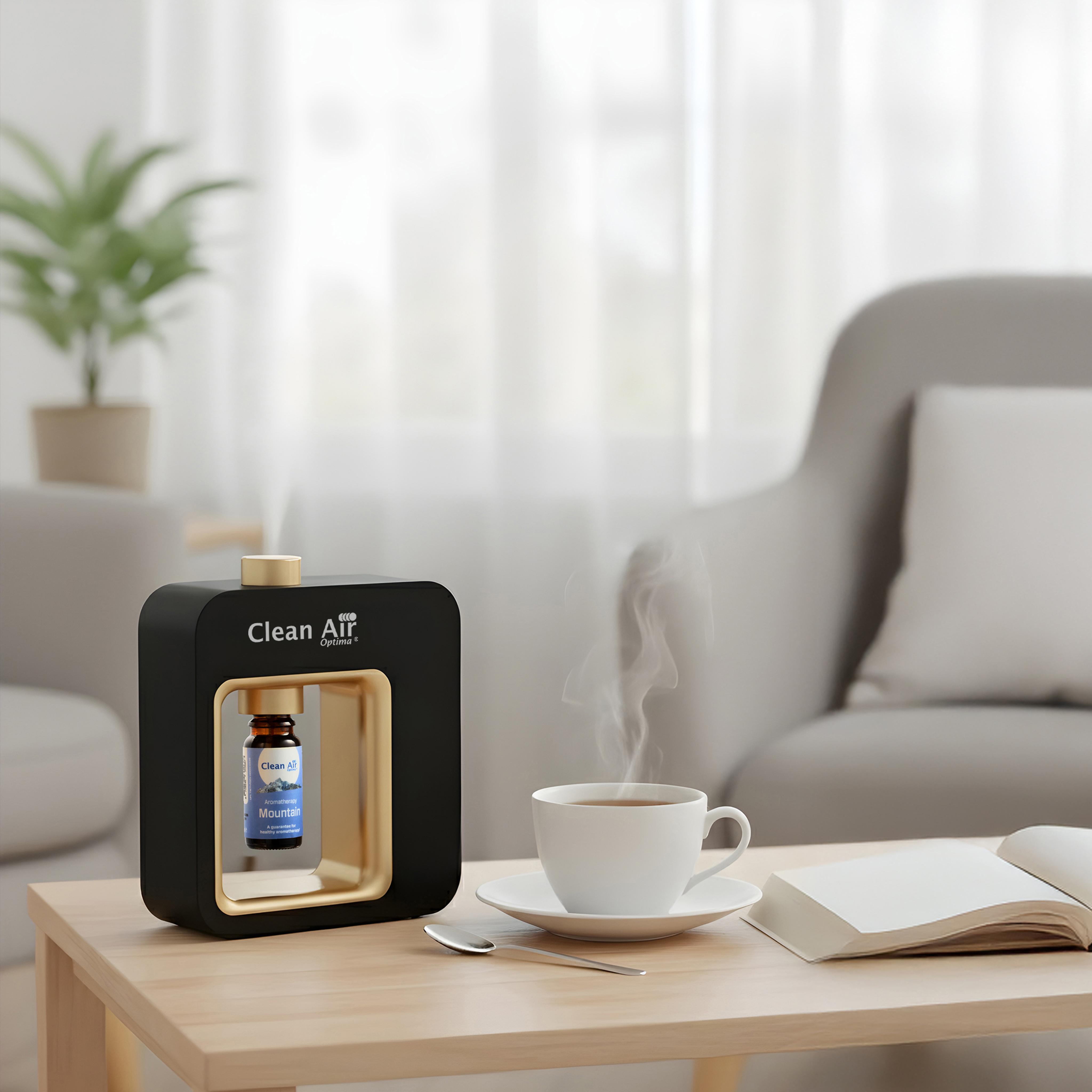 Een zwarte diffuser met flesje, dampende kop, kop en boek op houten tafel.