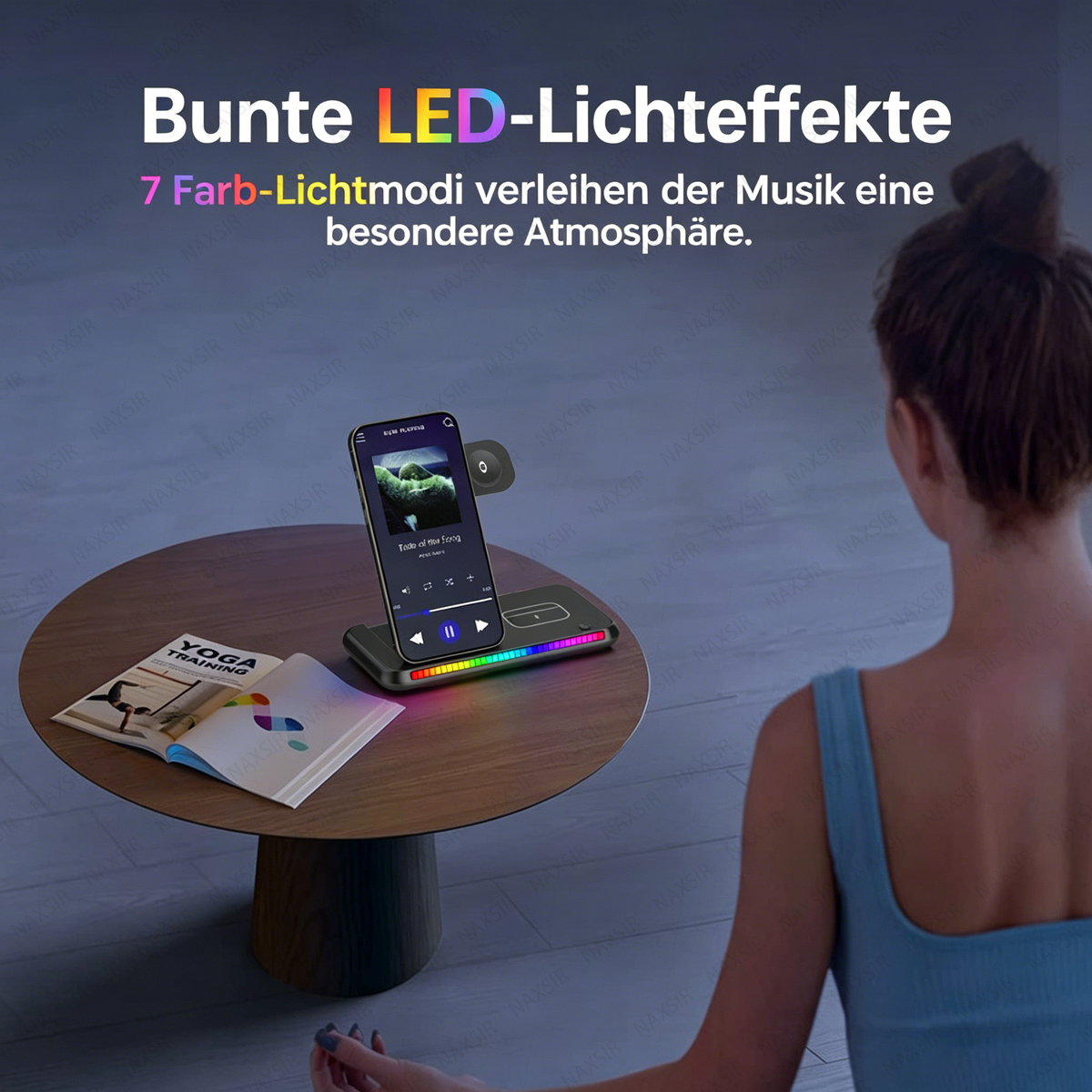 Ein Handy mit Musik und bunten LEDs steht auf einem Tisch neben einem Yogabuch.