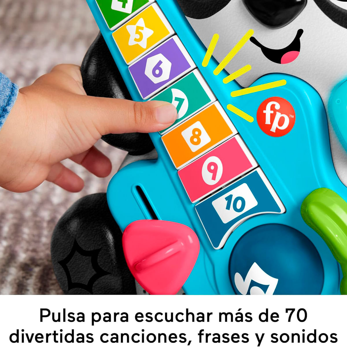 La mano de un niño presiona botones en una guitarra de juguete azul con números.
