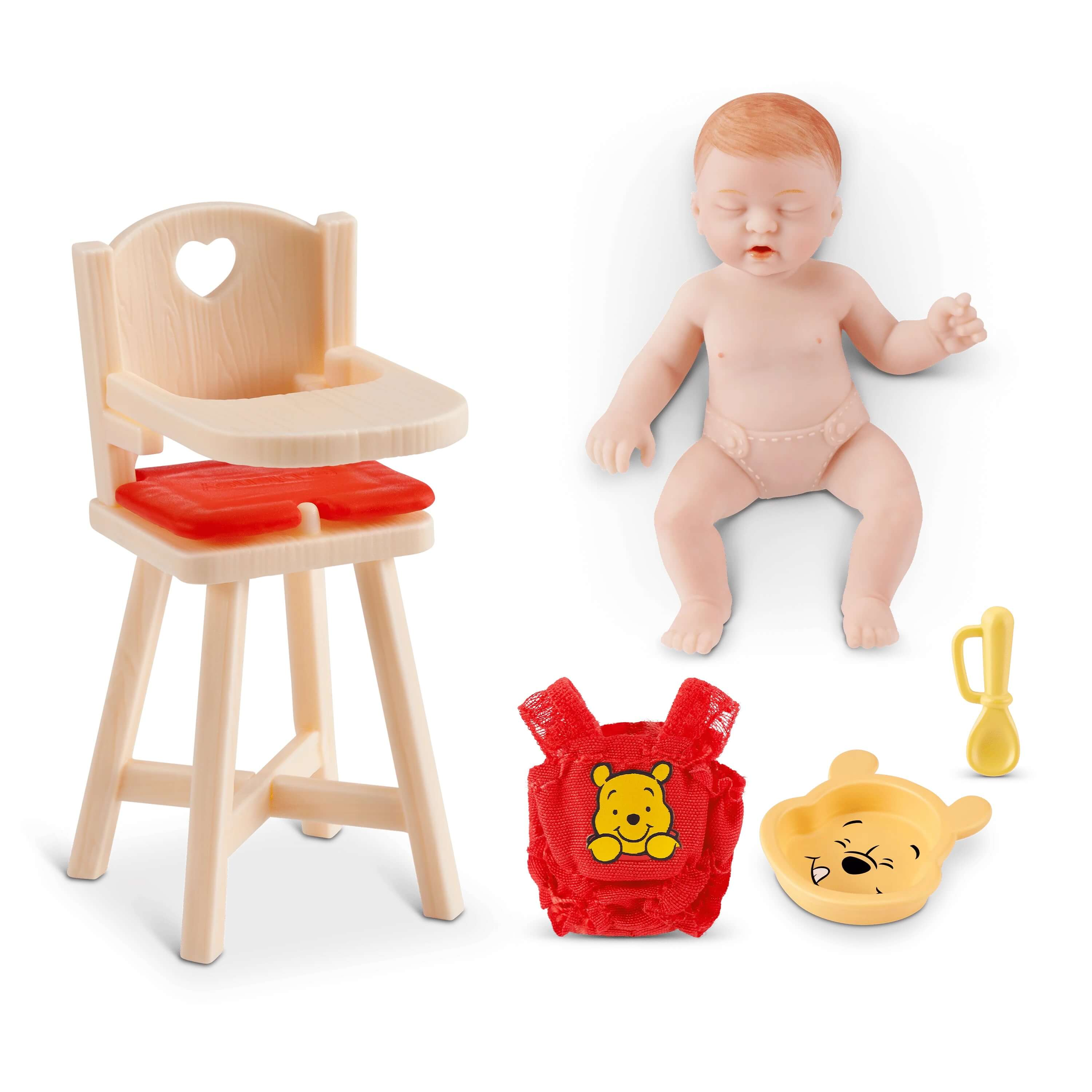 Un muñeco de bebé yace junto a una trona y accesorios como babero y cuchara.