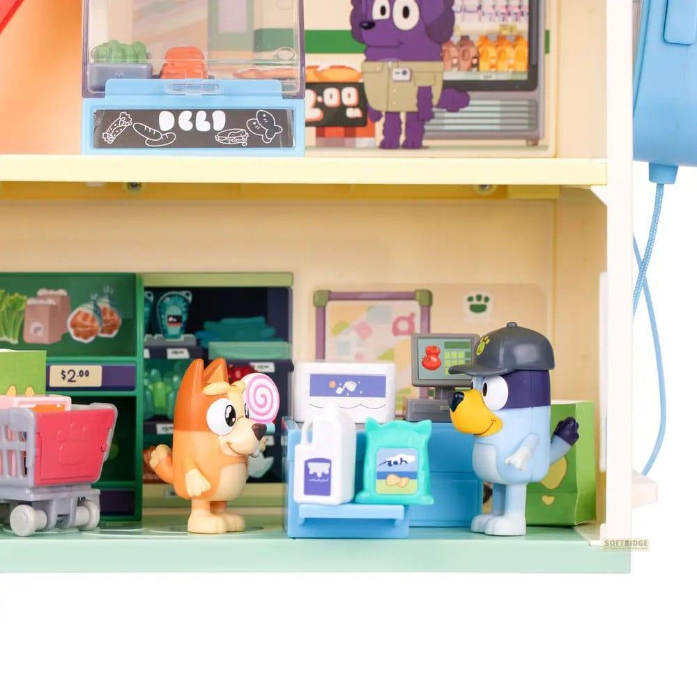 Dos figuras de juguete de perro delante de un estante de tienda con productos.