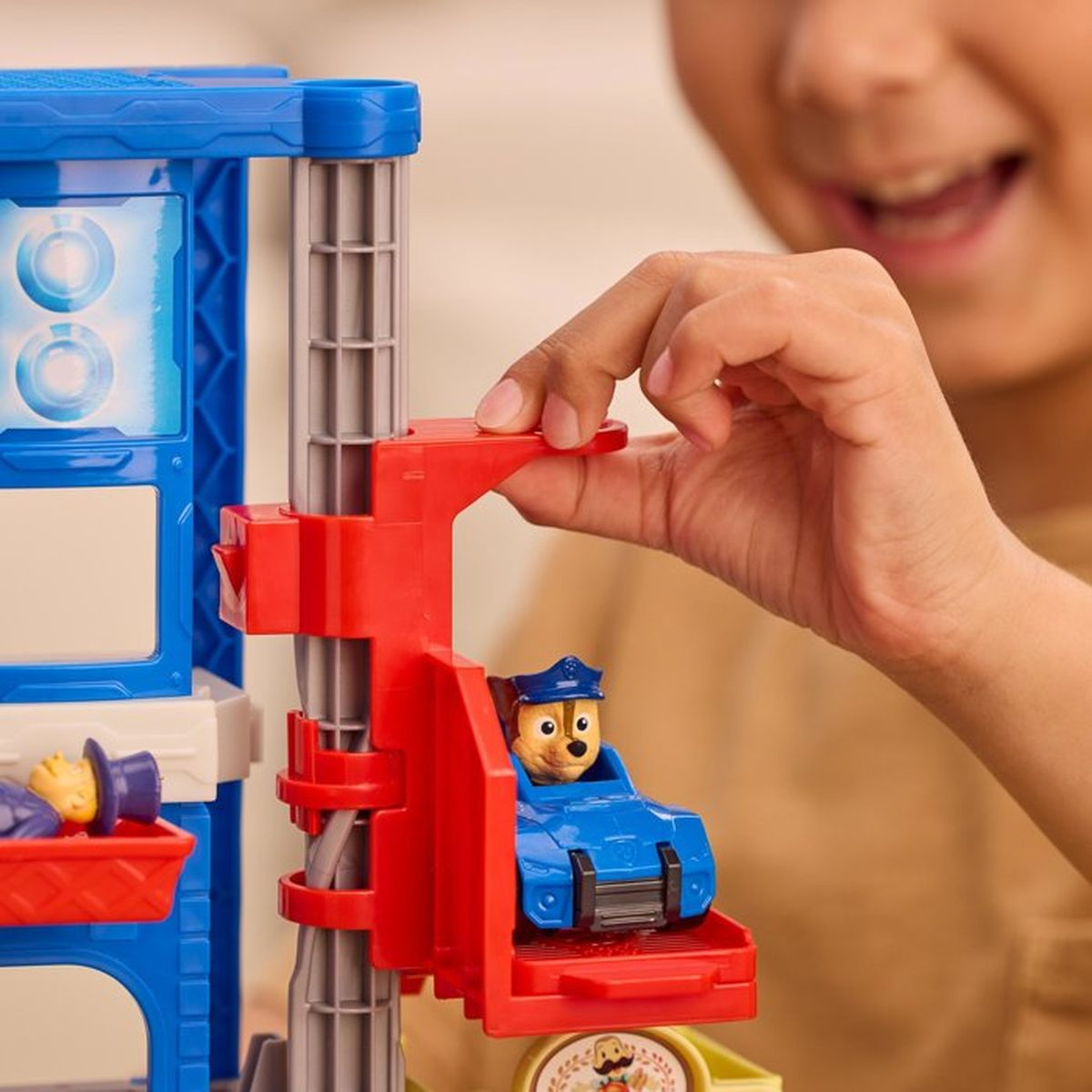 Un niño juega con un coche de juguete de Paw Patrol y una rampa.