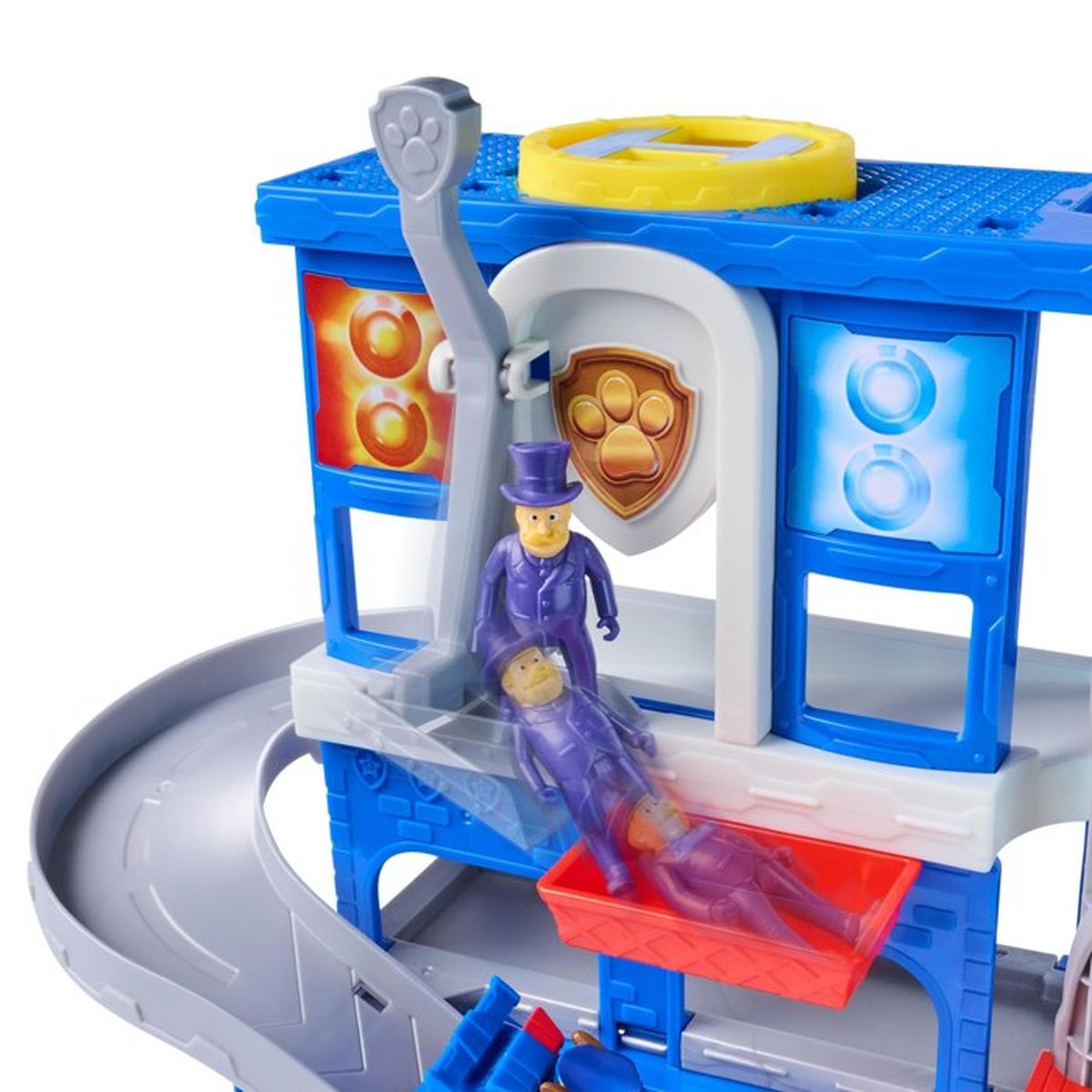 Figura de juguete en un tobogán de una torre de juguete azul con emblema de Paw Patrol.