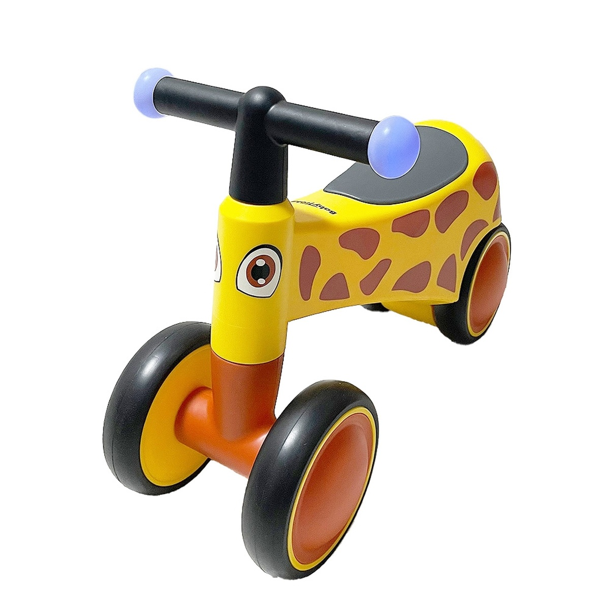 Ein gelbes Laufrad in Giraffenform mit braunen Flecken und blauen Griffen.