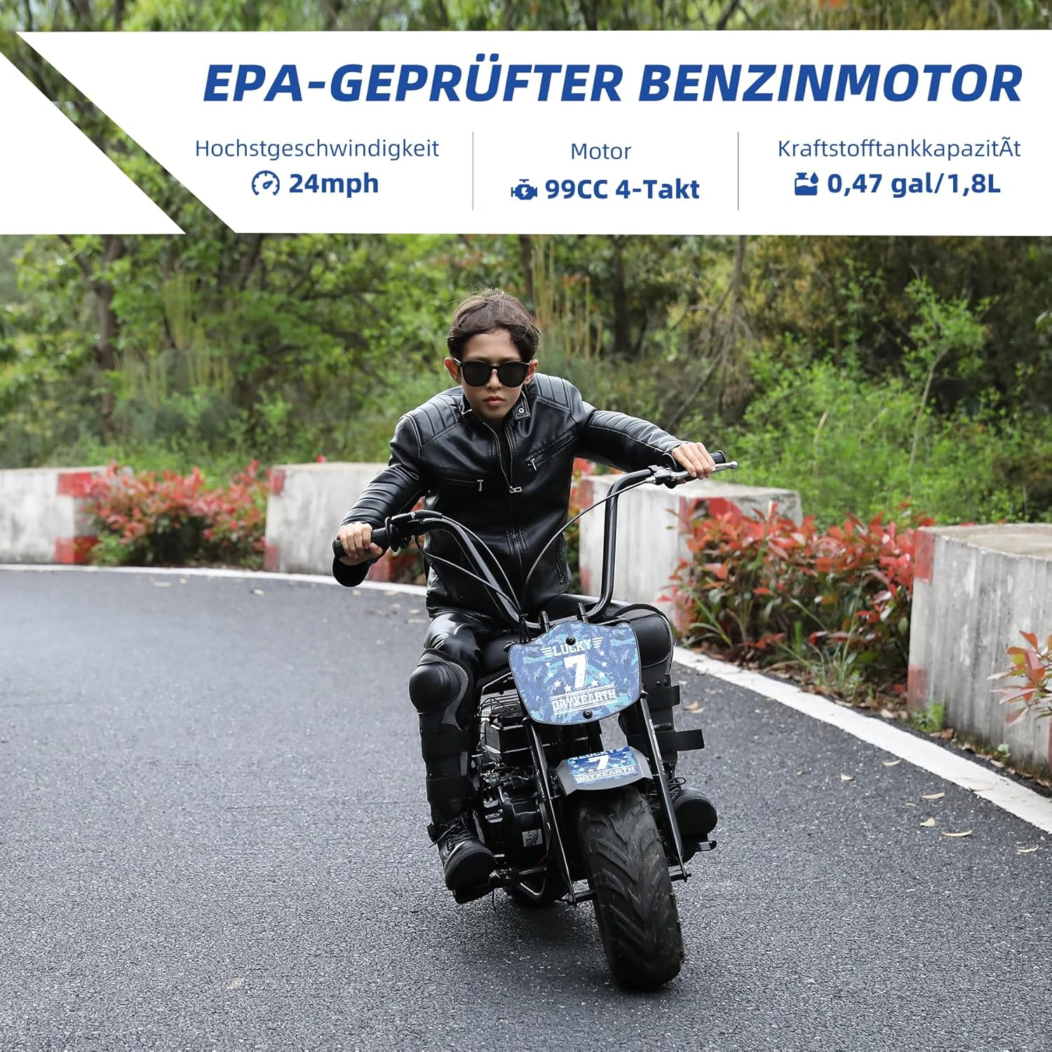 Ein Junge in Lederkleidung fährt ein kleines Motorrad auf einer asphaltierten Straße.