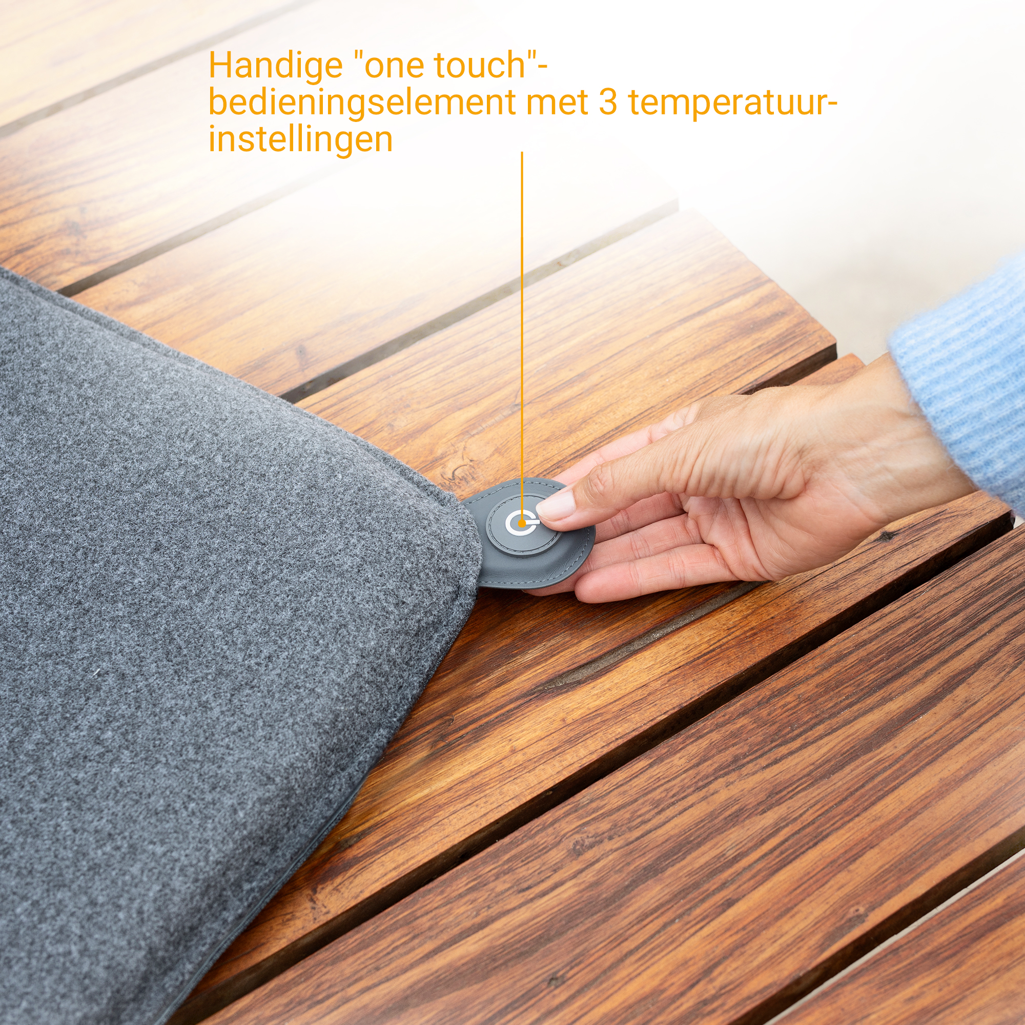 Grey cushion on wooden table with a button featuring a power symbol.