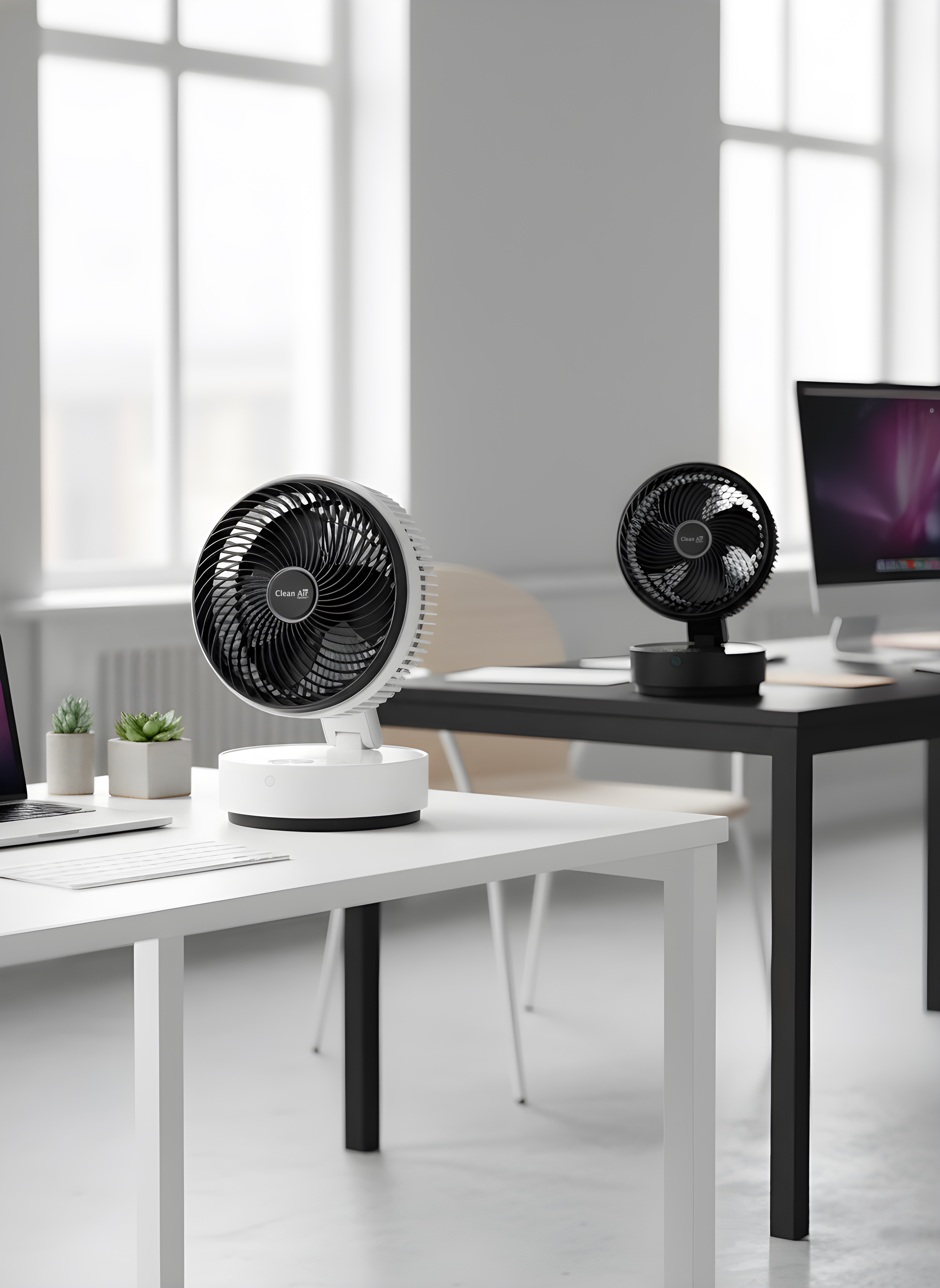 Two fans sit on desks in a modern office with large windows.