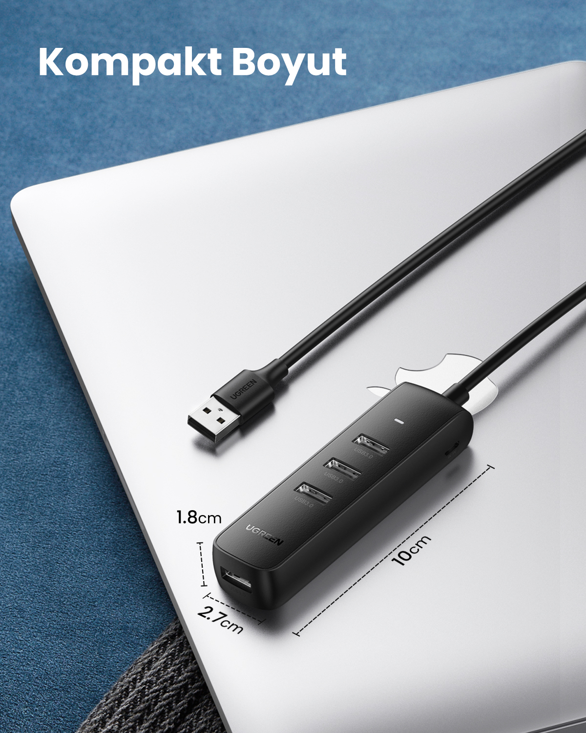 Czarny koncentrator USB z czterema portami i kablem USB na laptopie.