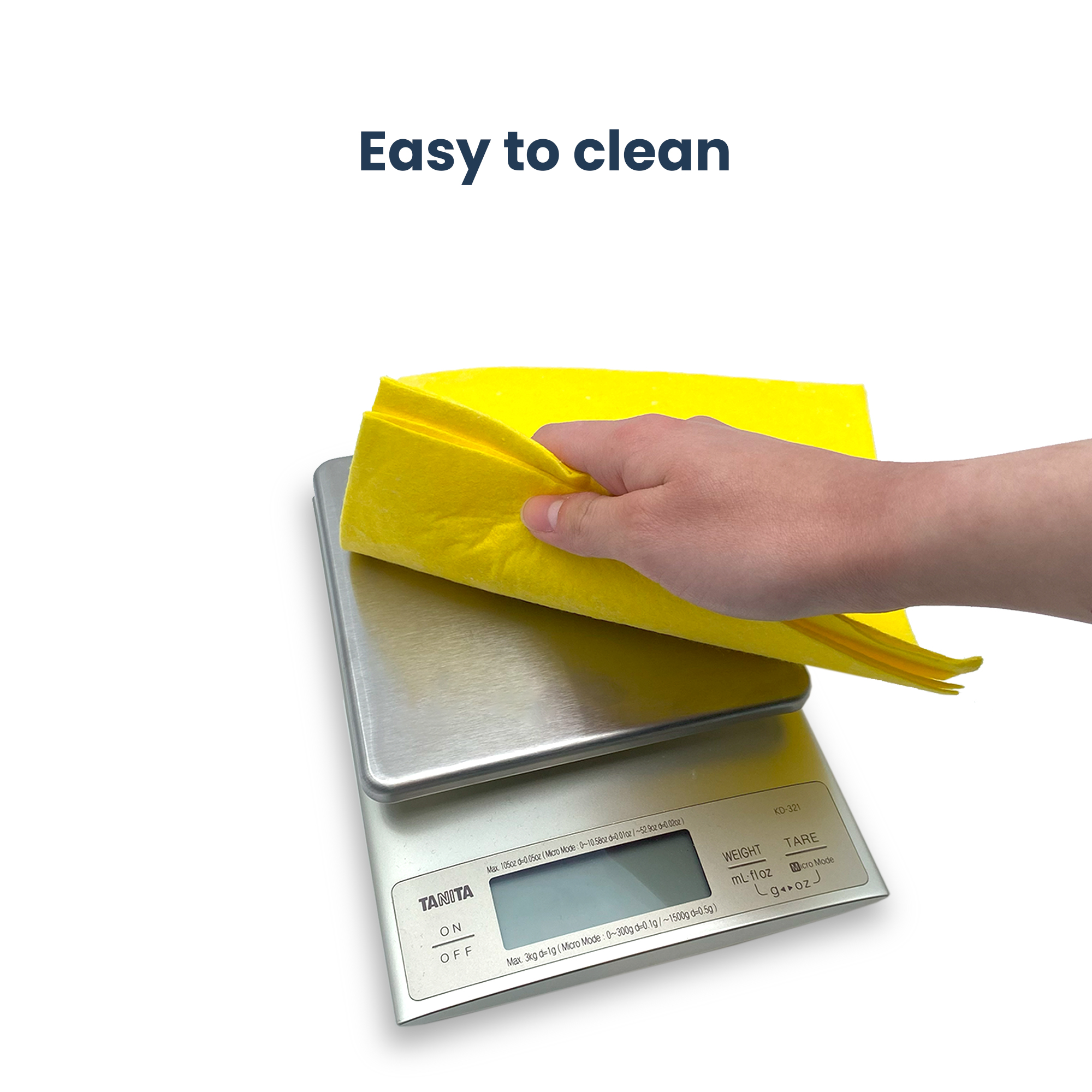 A hand holds a yellow cloth over a digital kitchen scale.