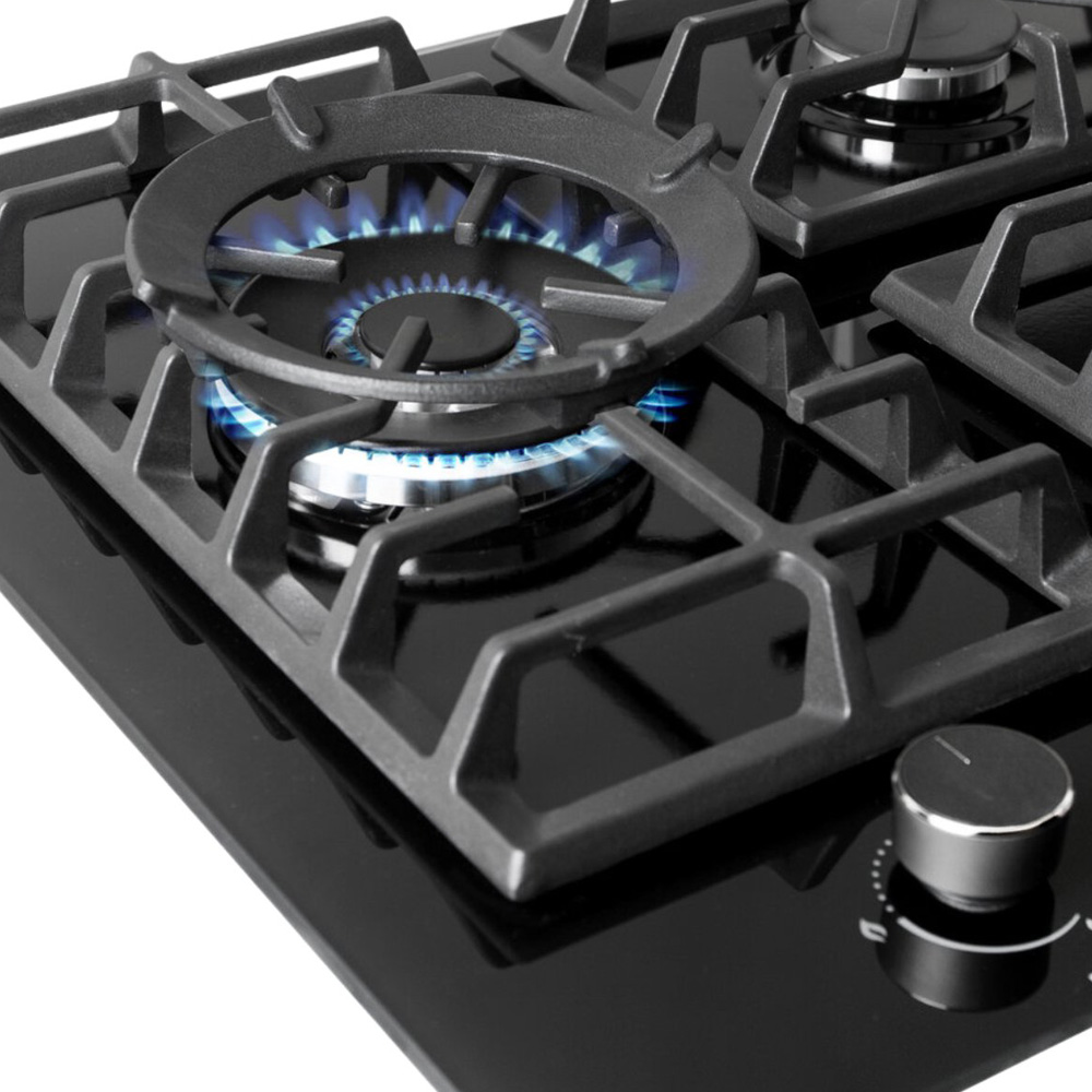 Une cuisinière à gaz en verre noir avec des flammes bleues.