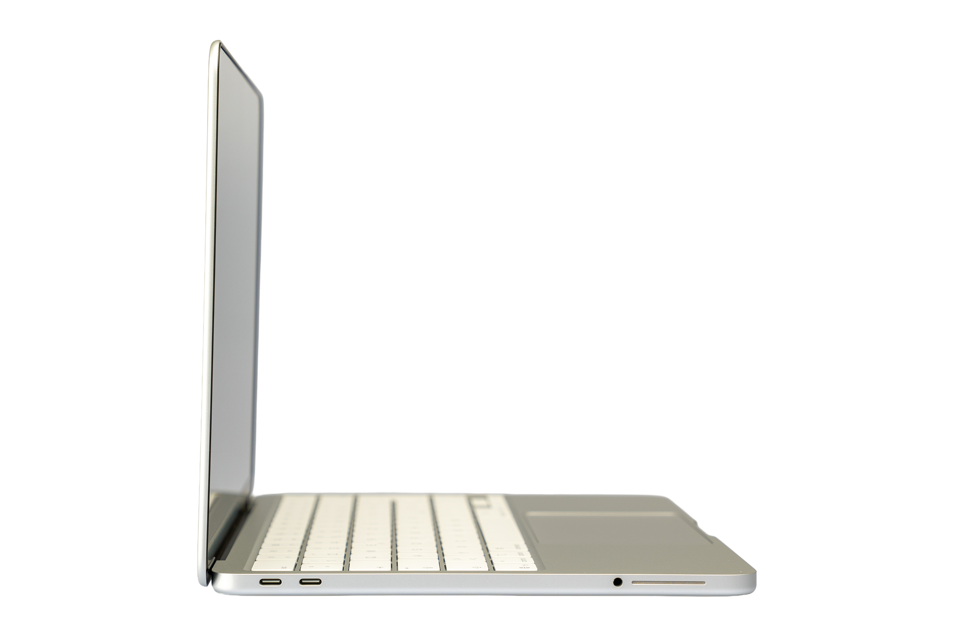 Un ordinateur portable argenté vu de côté, avec un clavier blanc.