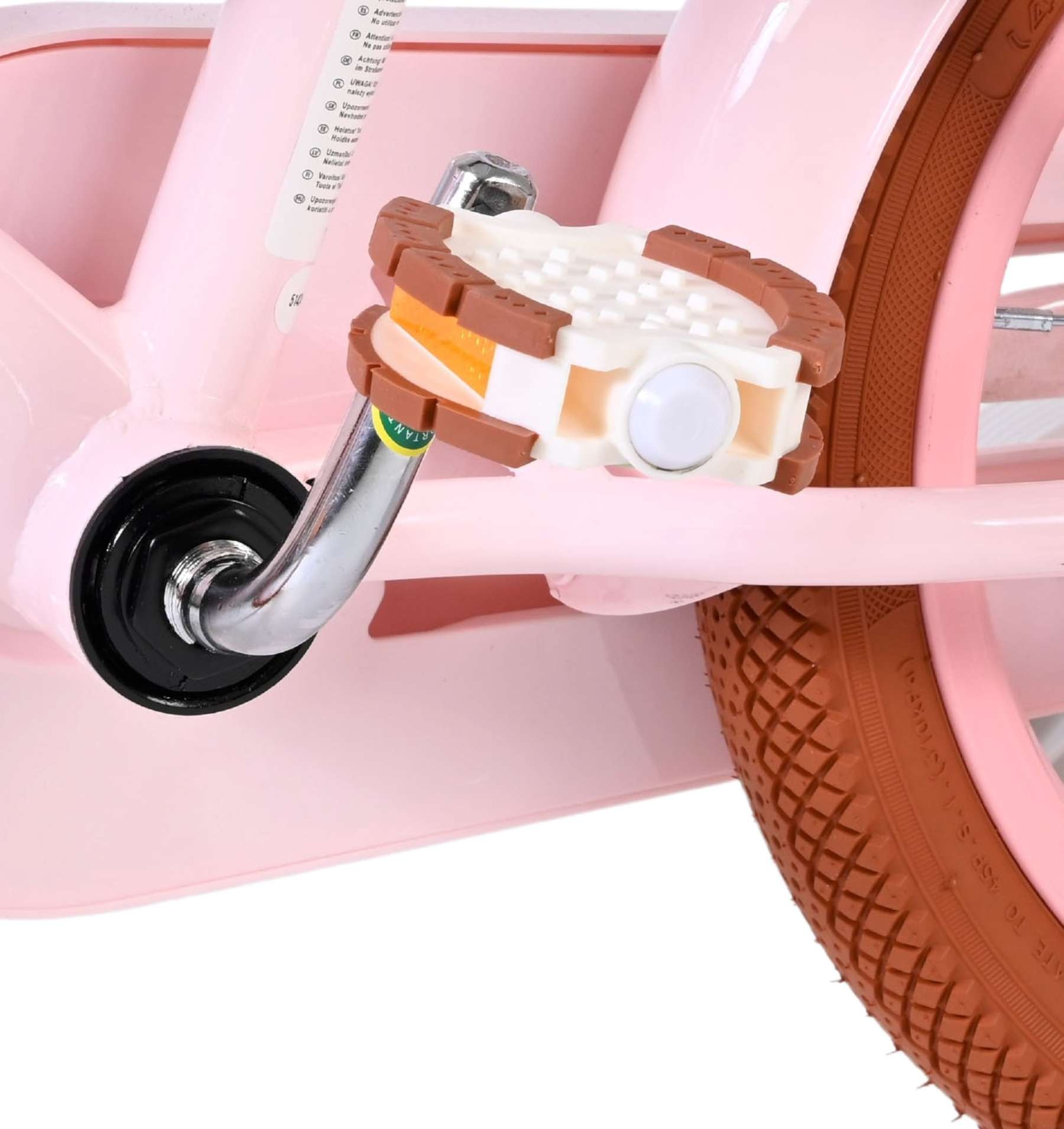 Nahaufnahme eines rosa Fahrradpedals mit braunem Reifen und Warnhinweisen.