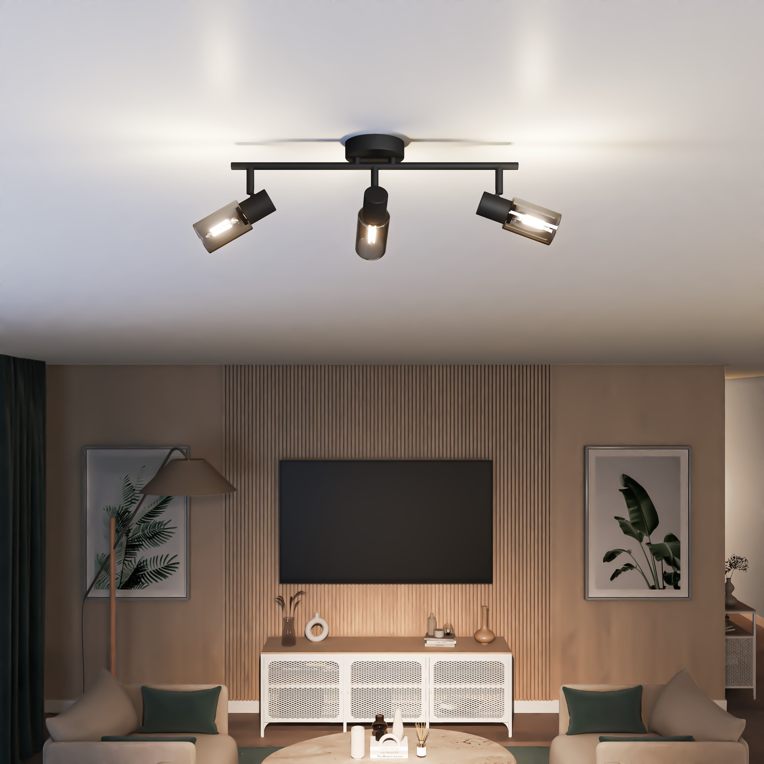 Schwarzer Deckenstrahler mit drei verstellbaren Spots über einem modernen Wohnzimmer mit Fernseher.