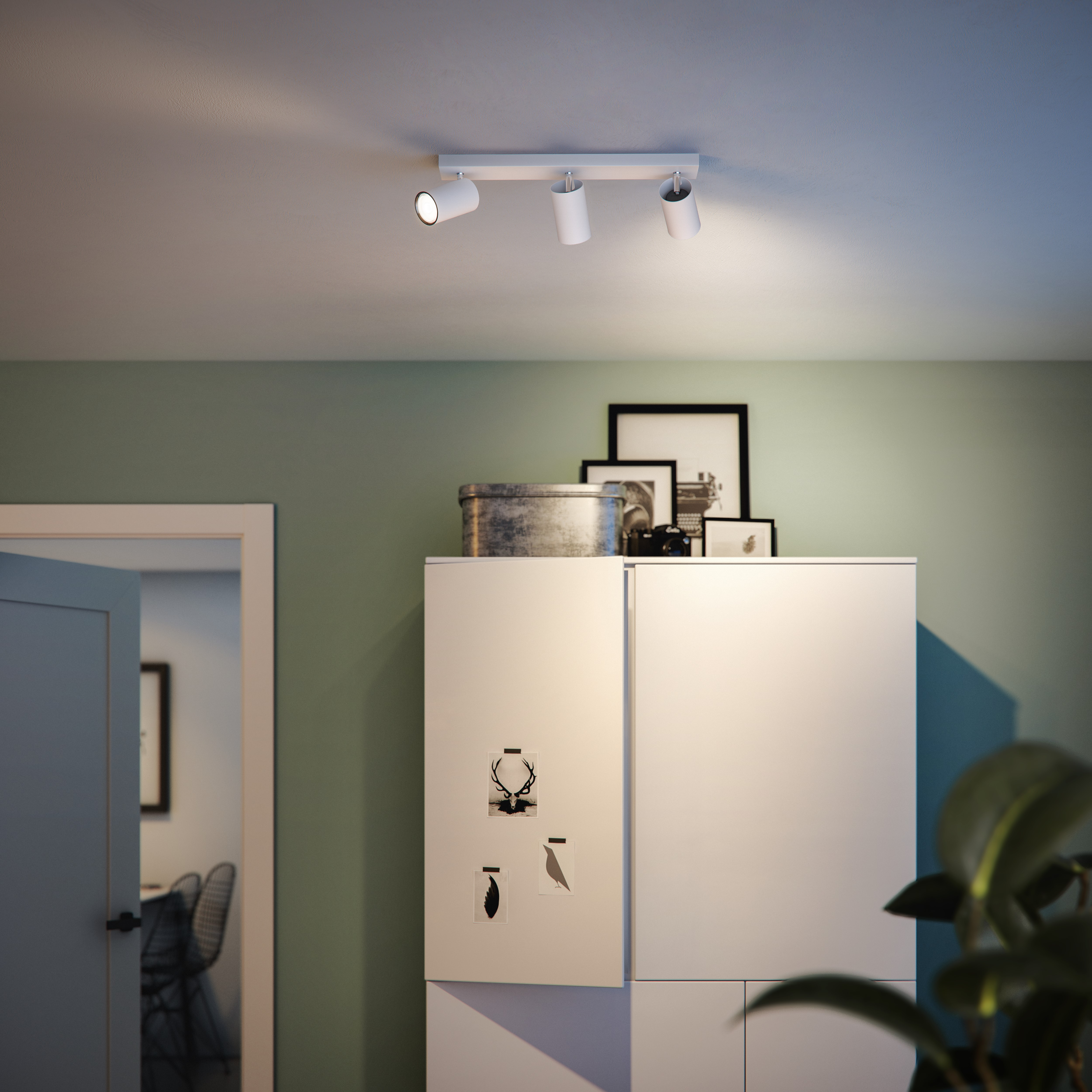 Deckenstrahler mit drei weißen Spots über einem weißen Schrank.