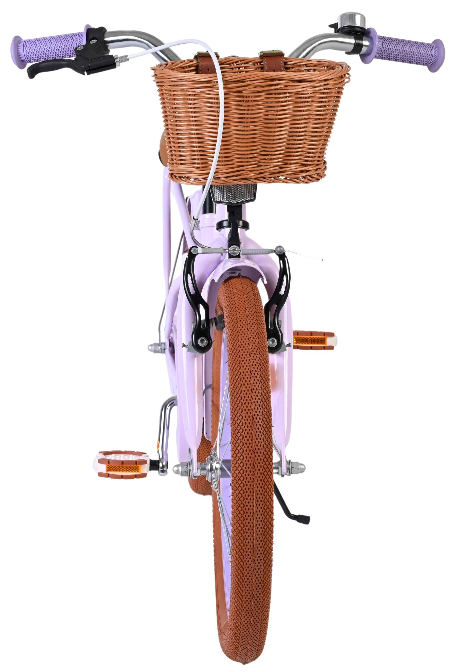 Ein lila Fahrrad mit einem Weidenkorb vorne und braunen Reifen.
