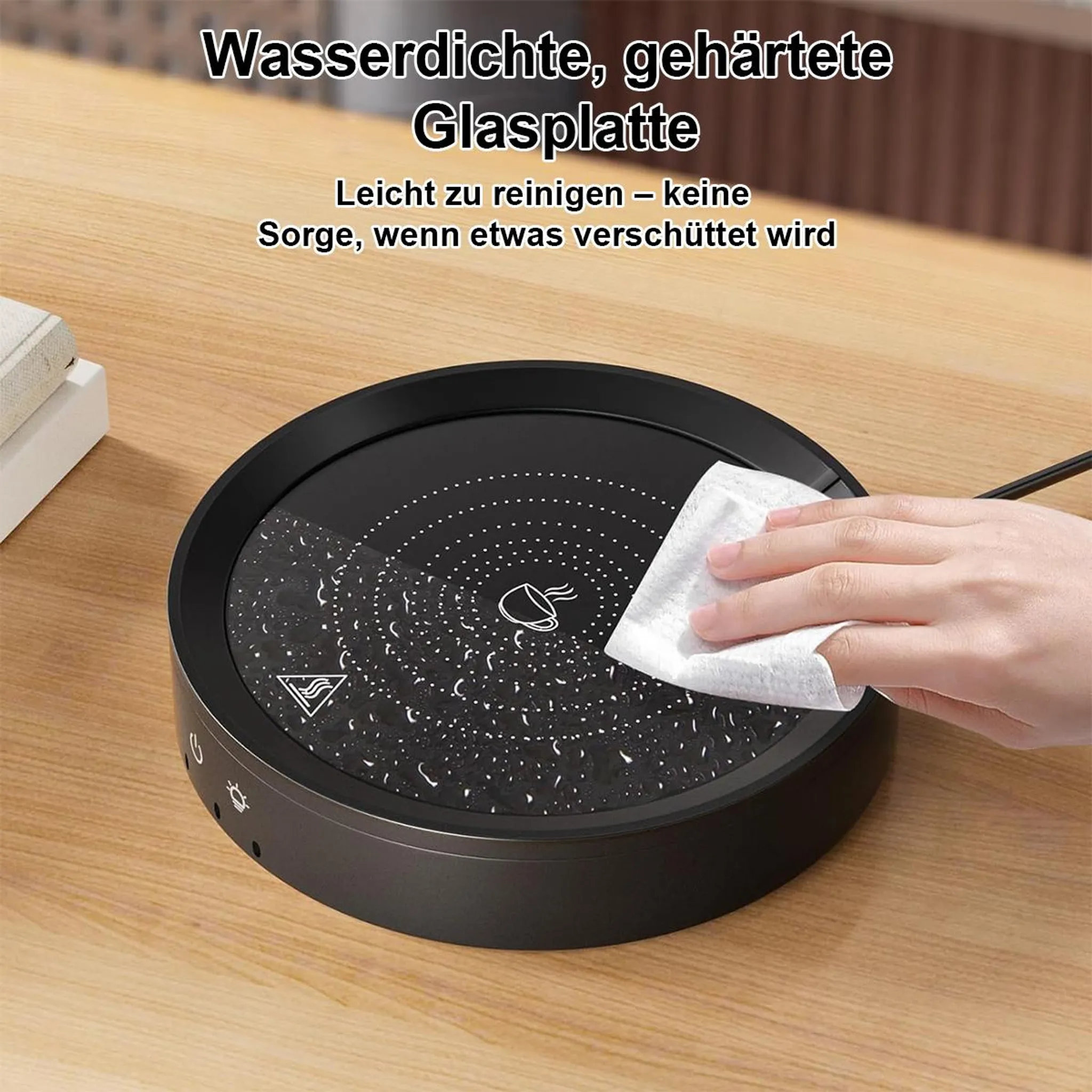 Eine Hand wischt eine schwarze, runde Glasplatte mit einem weißen Tuch ab.