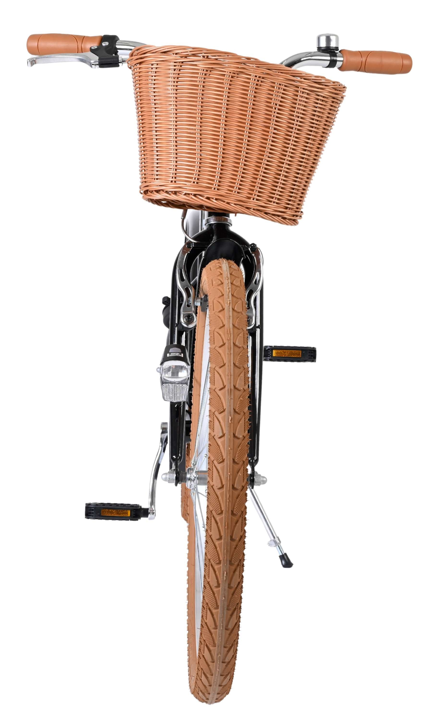 Ein Fahrrad mit einem braunen Weidenkorb vorne, braunen Griffen und einem braunen Reifen.