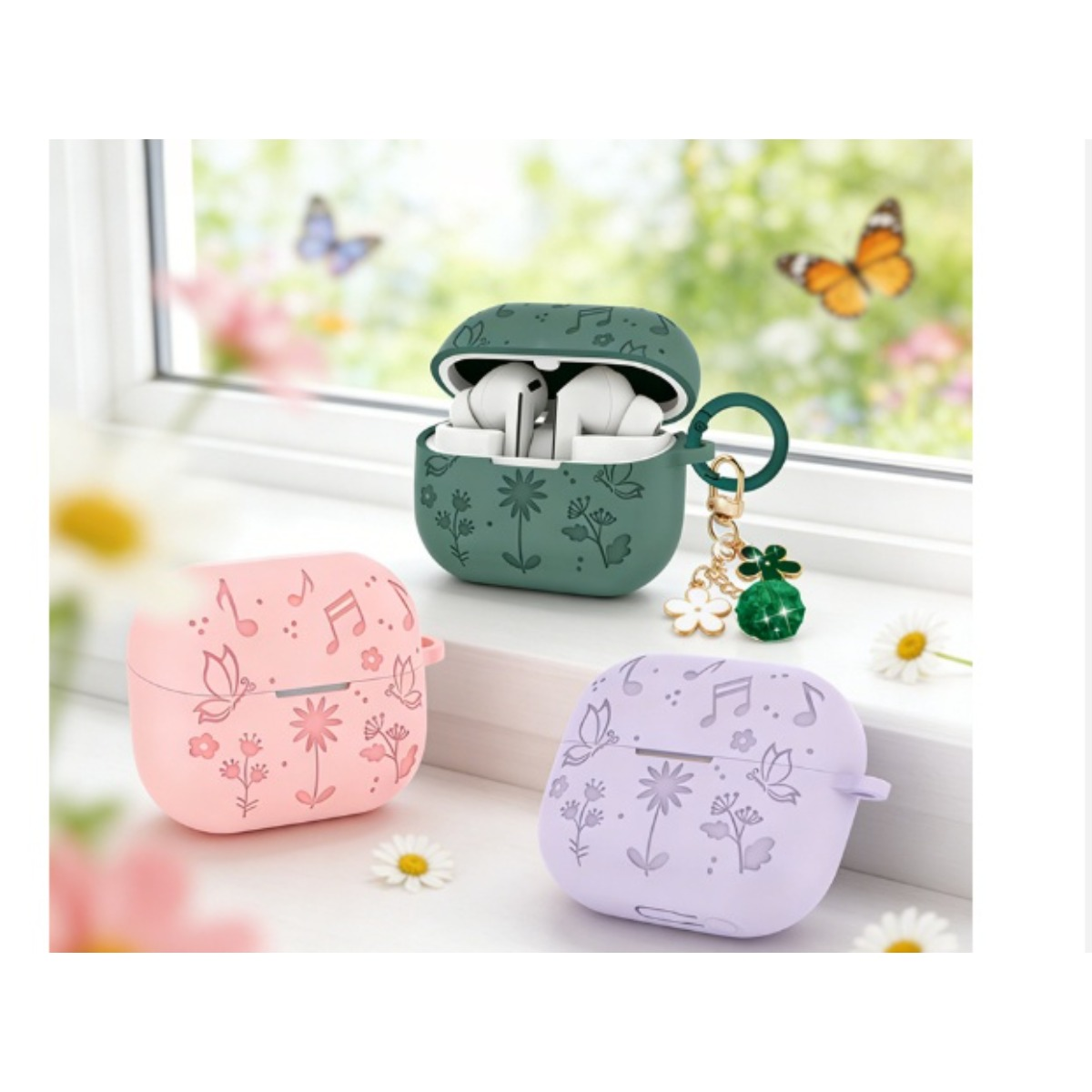 Drei Kopfhörerhüllen in Grün, Rosa und Lila mit Blumen- und Notenmuster.