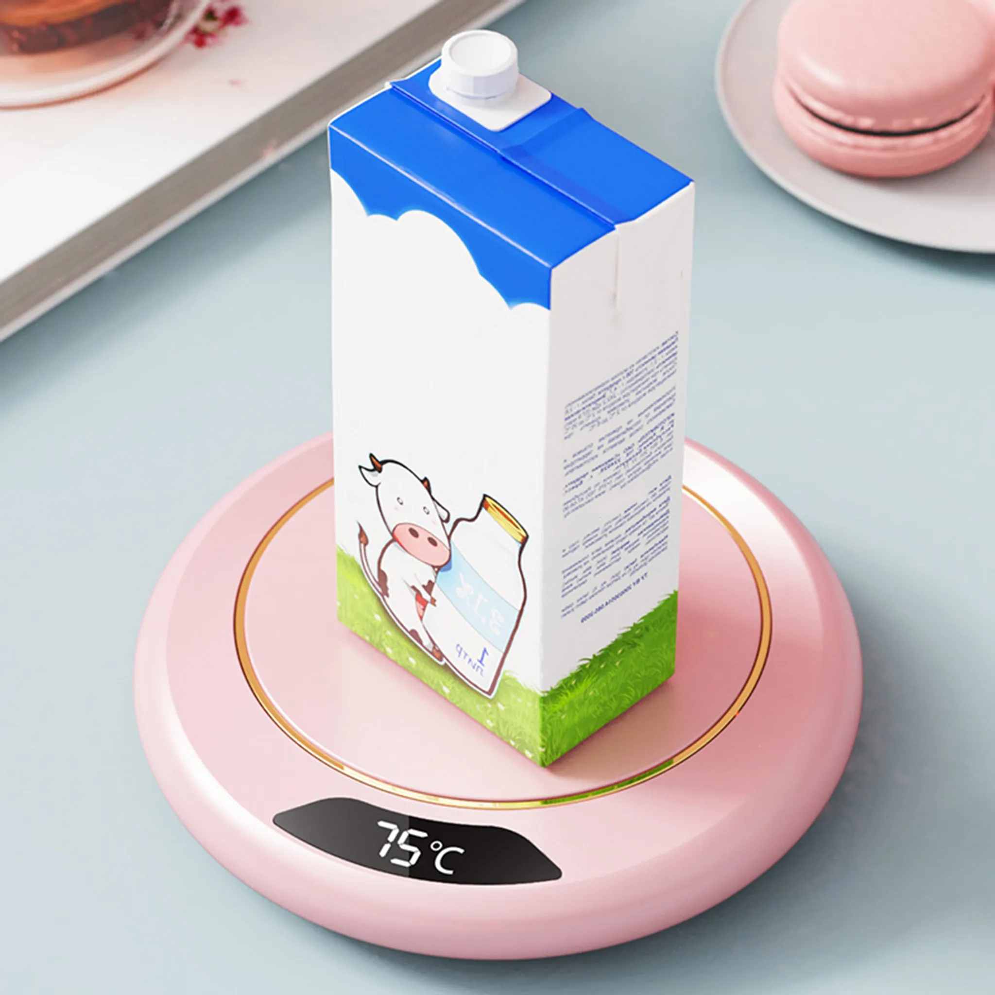 Eine Milchpackung mit Kuhmotiv auf einem rosa Untersetzer mit Temperaturanzeige.