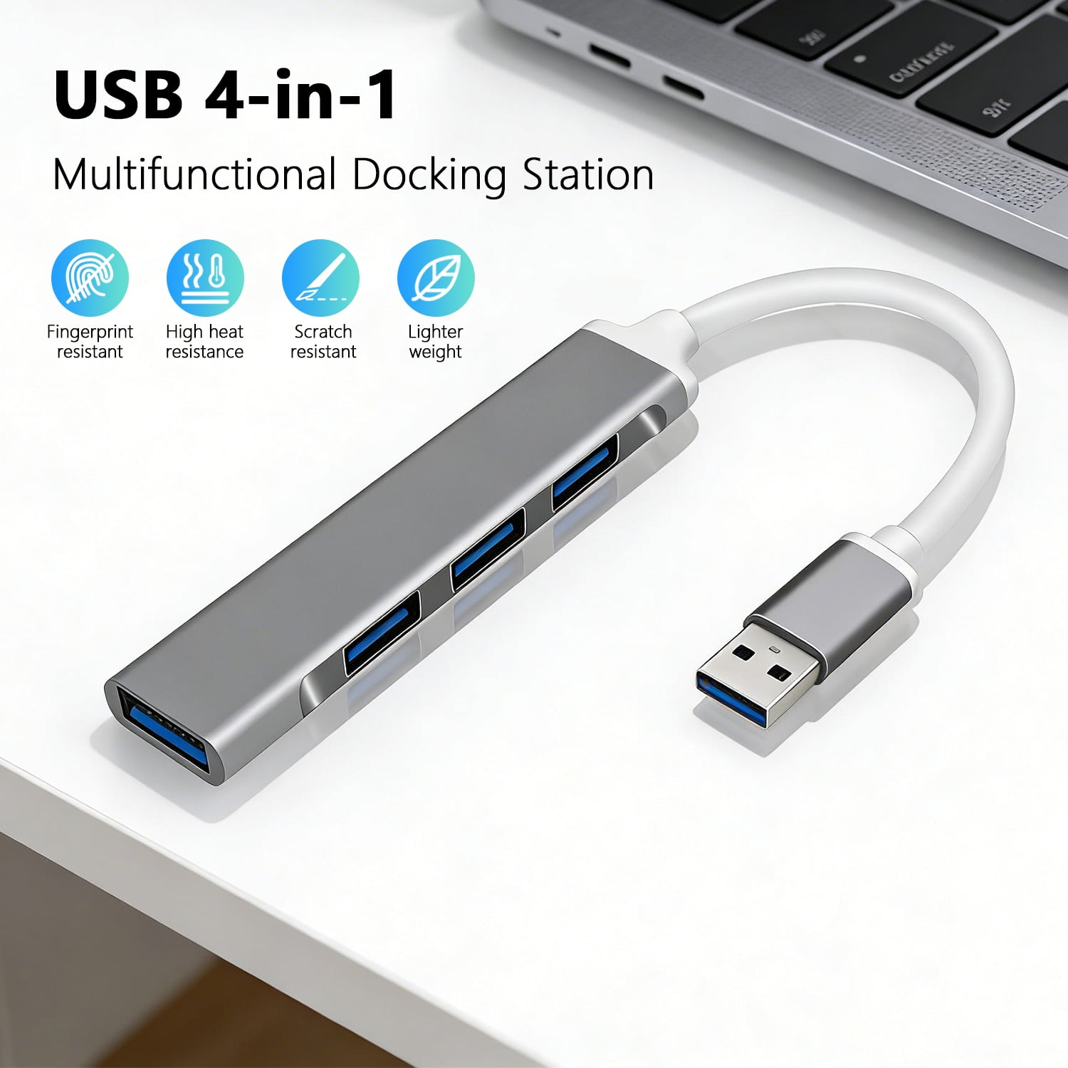 Grauer USB-Hub mit 4 Anschlüssen und weißem Kabel, daneben ein Laptop.
