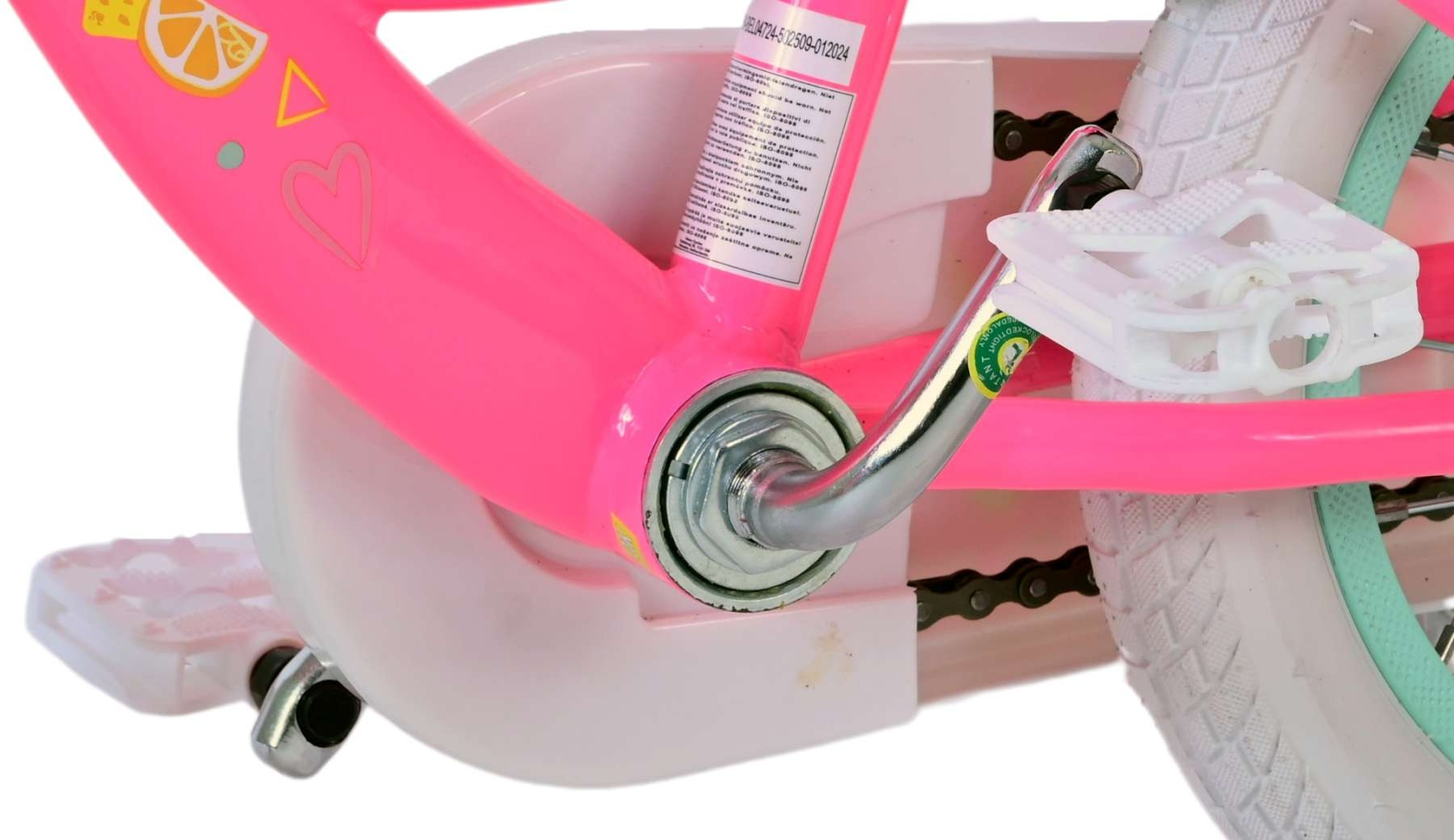 Nahaufnahme des pinken Rahmens eines Kinderfahrrads mit weißen Pedalen und Reifen.