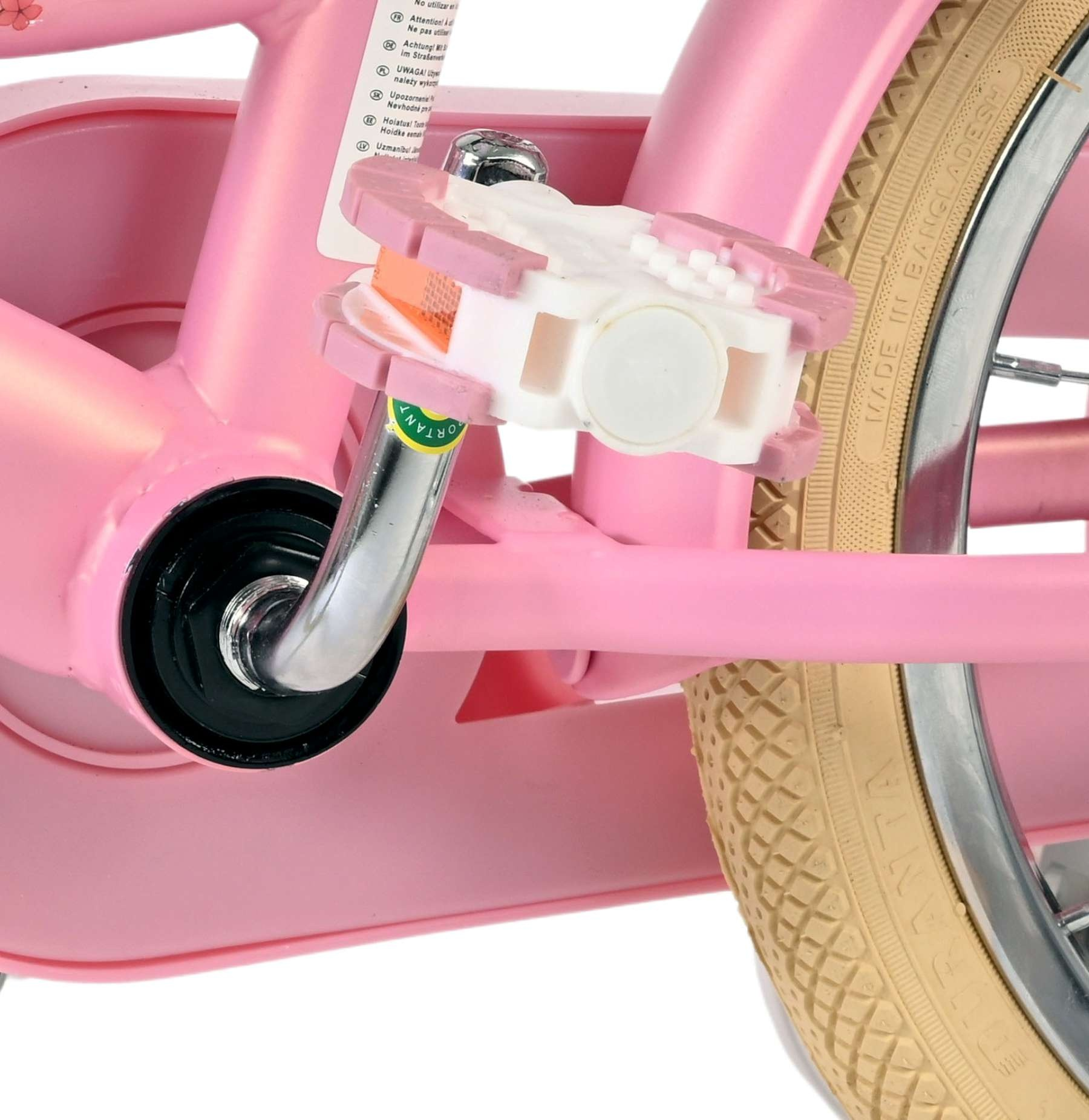 Ein pinker Fahrradrahmen mit weiß-pinken Pedalen und einem beige Reifen.