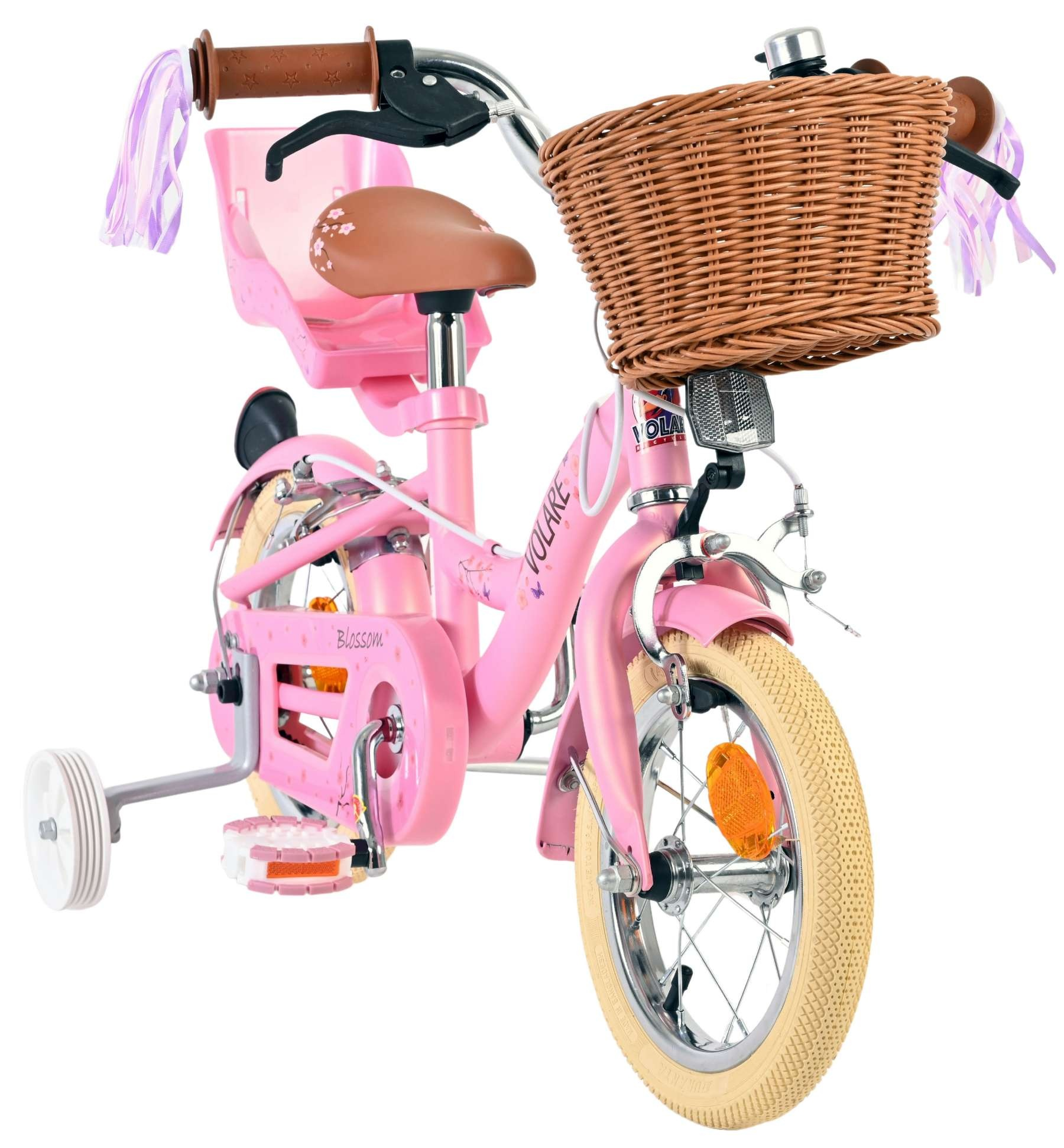 Ein pinkes Kinderfahrrad mit Weidenkorb, Stützrädern und Fähnchen.