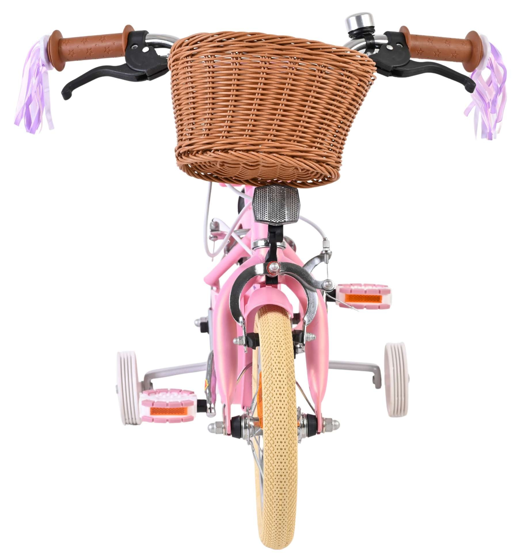 Rosa Kinderfahrrad mit Weidenkorb, Stützrädern und Lenkerbändern.