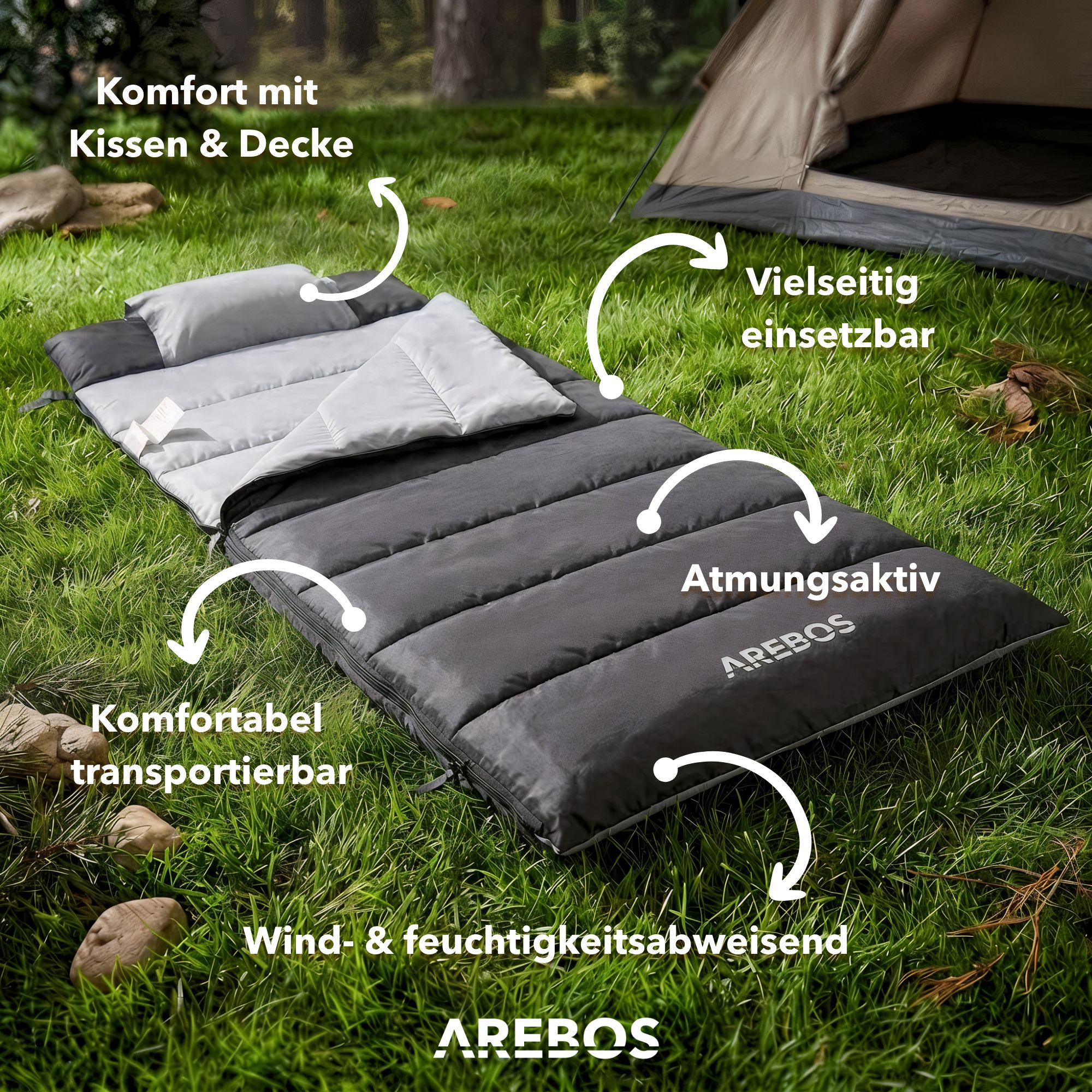 Ein grauer Schlafsack mit Kissen und Decke liegt auf Gras neben einem Zelt.
