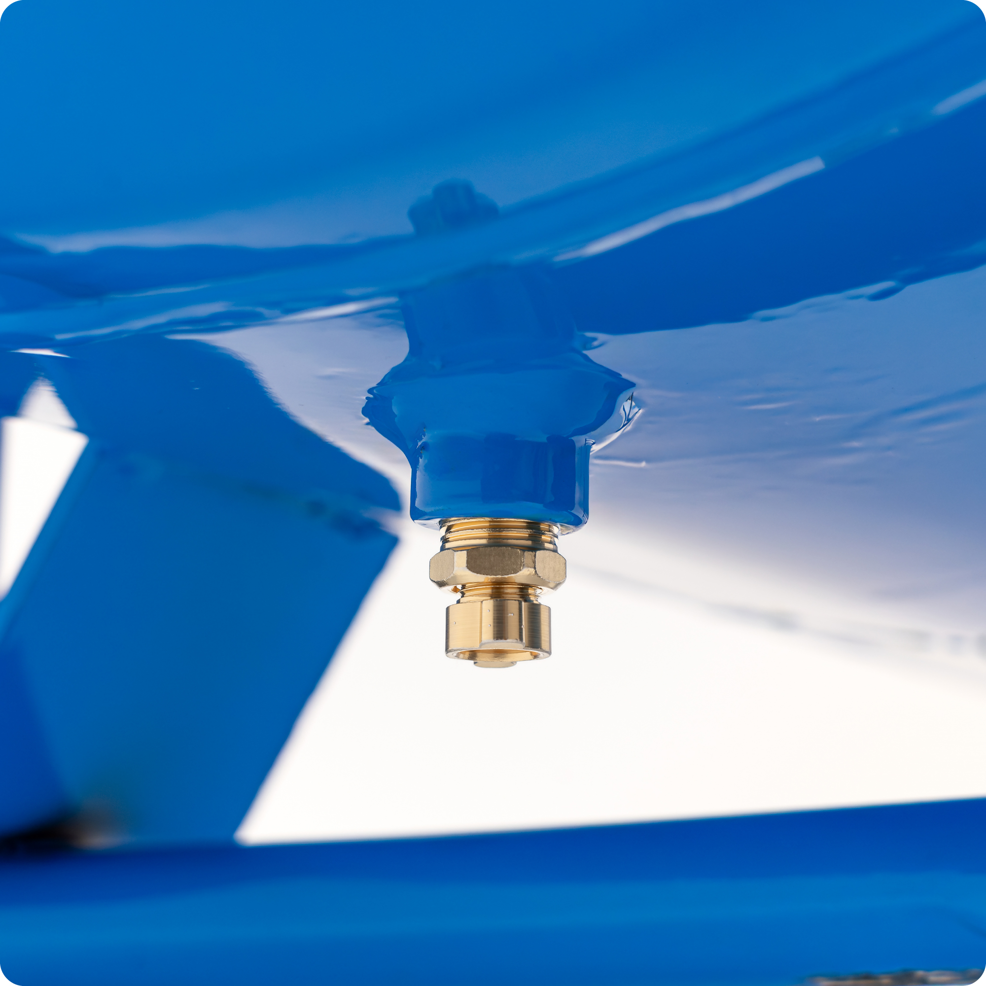 Ein goldener Messingnippel ist an einer blauen Metallhalterung befestigt.