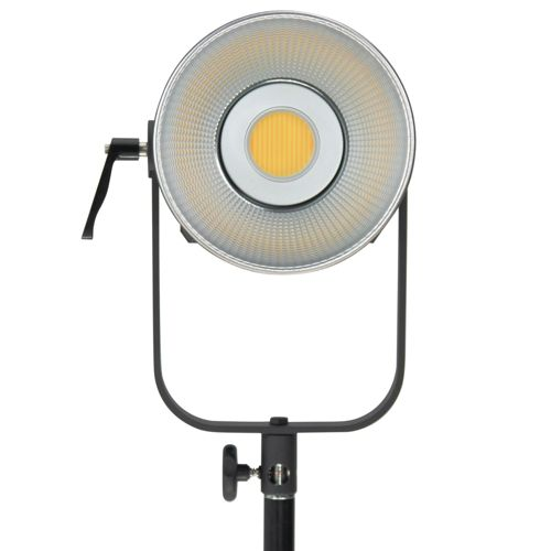 Ein silberner LED-Scheinwerfer mit gelbem Zentrum, montiert auf einem schwarzen Ständer.