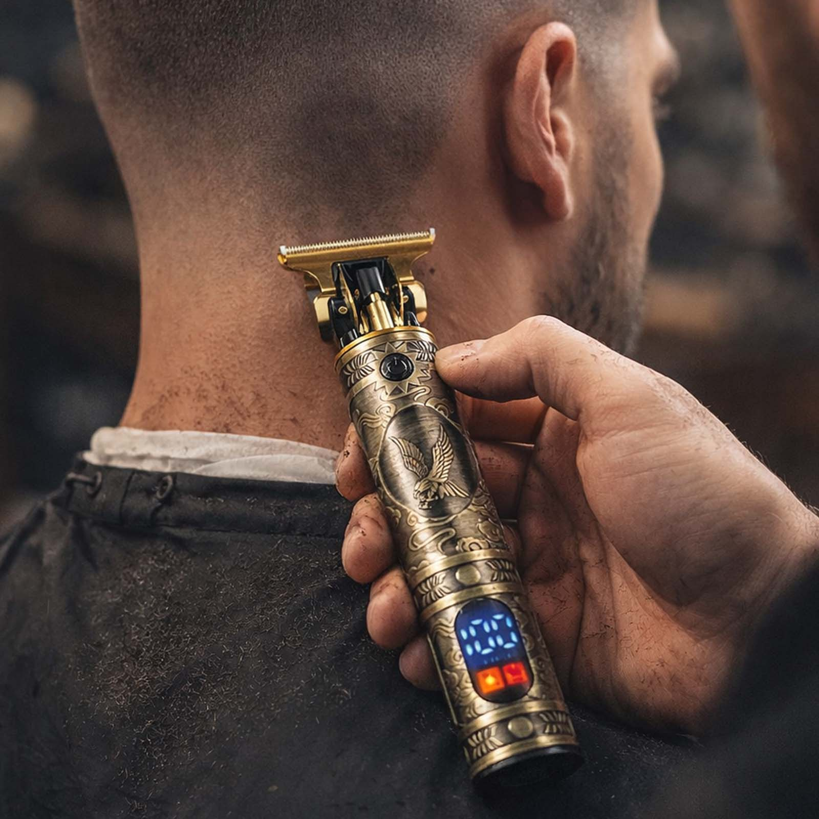 Goldene Haarschneidemaschine mit Adler-Gravur, die den Nacken eines Mannes trimmt.