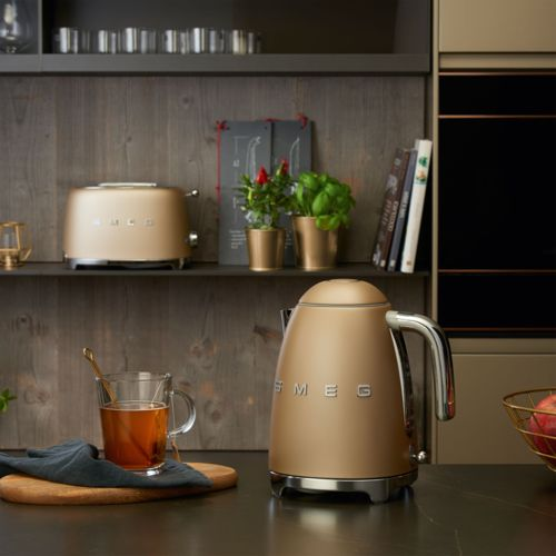 Altın rengi Smeg su ısıtıcısı ve tost makinesi karanlık tezgahta.