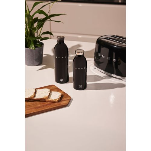 Zwei schwarze Smeg-Flaschen, Toastbrot mit Butter und ein Toaster auf einer Arbeitsplatte.