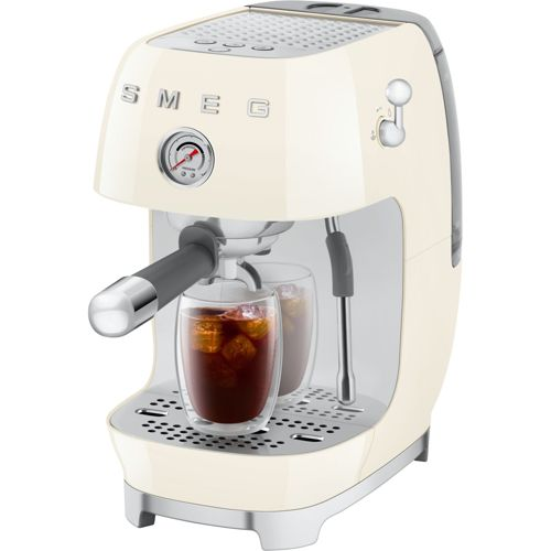 Eine cremefarbene Smeg-Espressomaschine brüht Kaffee in zwei Gläser mit Eiswürfeln.