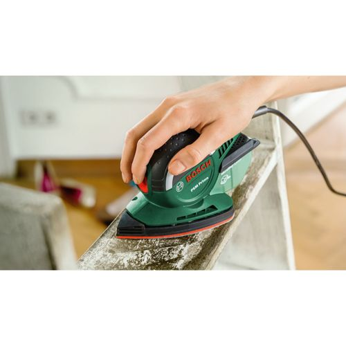 Eine Hand benutzt einen grünen Bosch-Schleifer, um eine Holztreppe zu schleifen.