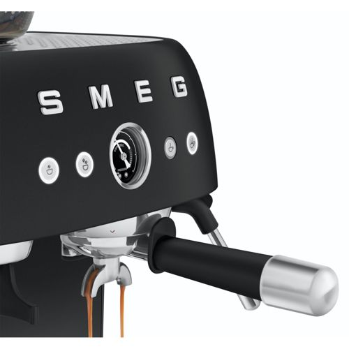 Máquina de espresso negra con detalles cromados, grupo de preparación con café saliendo.